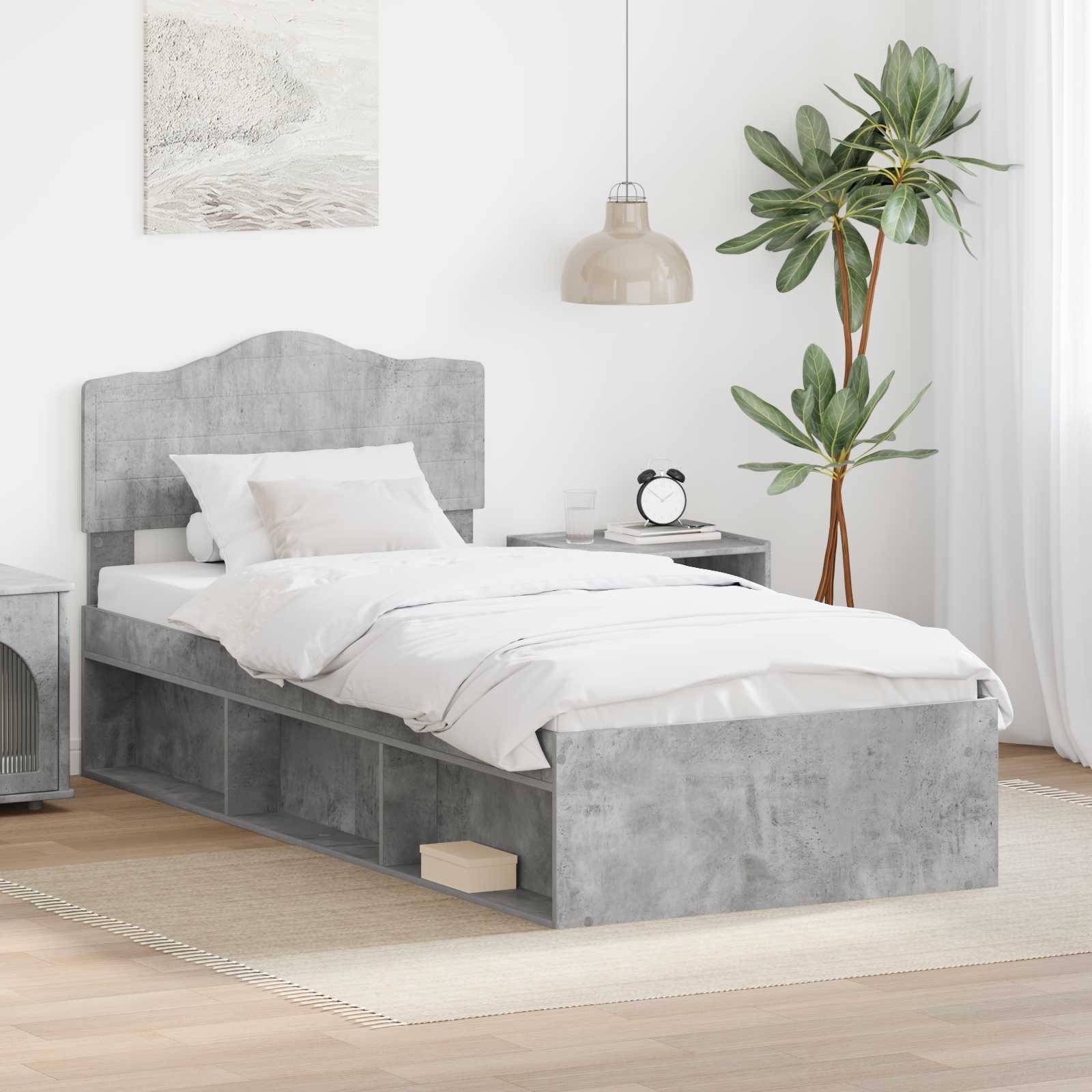 Ein modernes Schlafzimmer mit einem grauen Bettgestell, weißer Bettwäsche, zwei Kissen, einem Nachttisch mit Deko, einer Pflanze und einer Pendelleuchte, die eine ruhige Atmosphäre schafft.