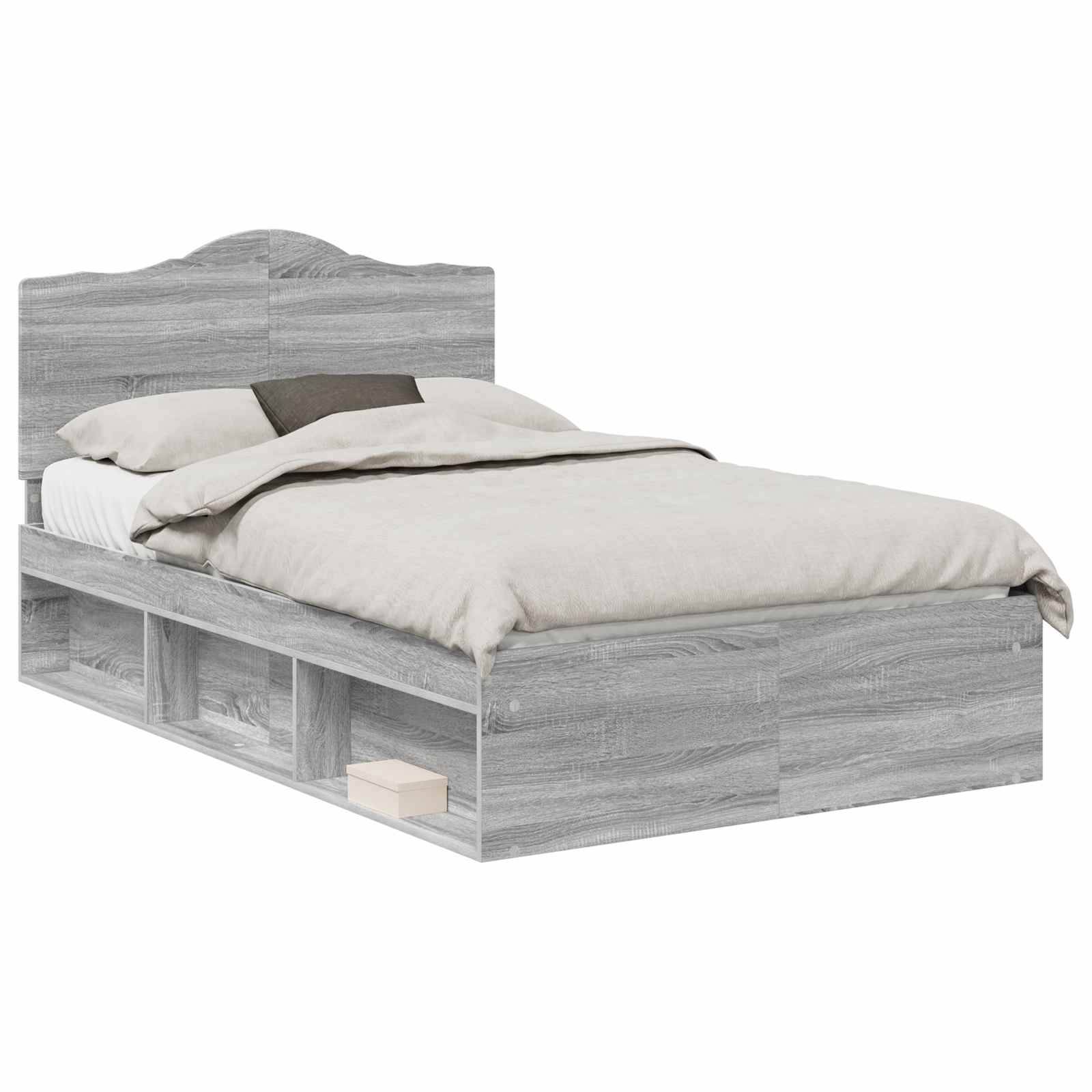 Ein Einzelbett mit einem Holzkopfteil und einem hellgrauen Finish, das offene Ablageregale darunter aufweist. Die Bettwäsche umfasst beige Laken und Kissen.