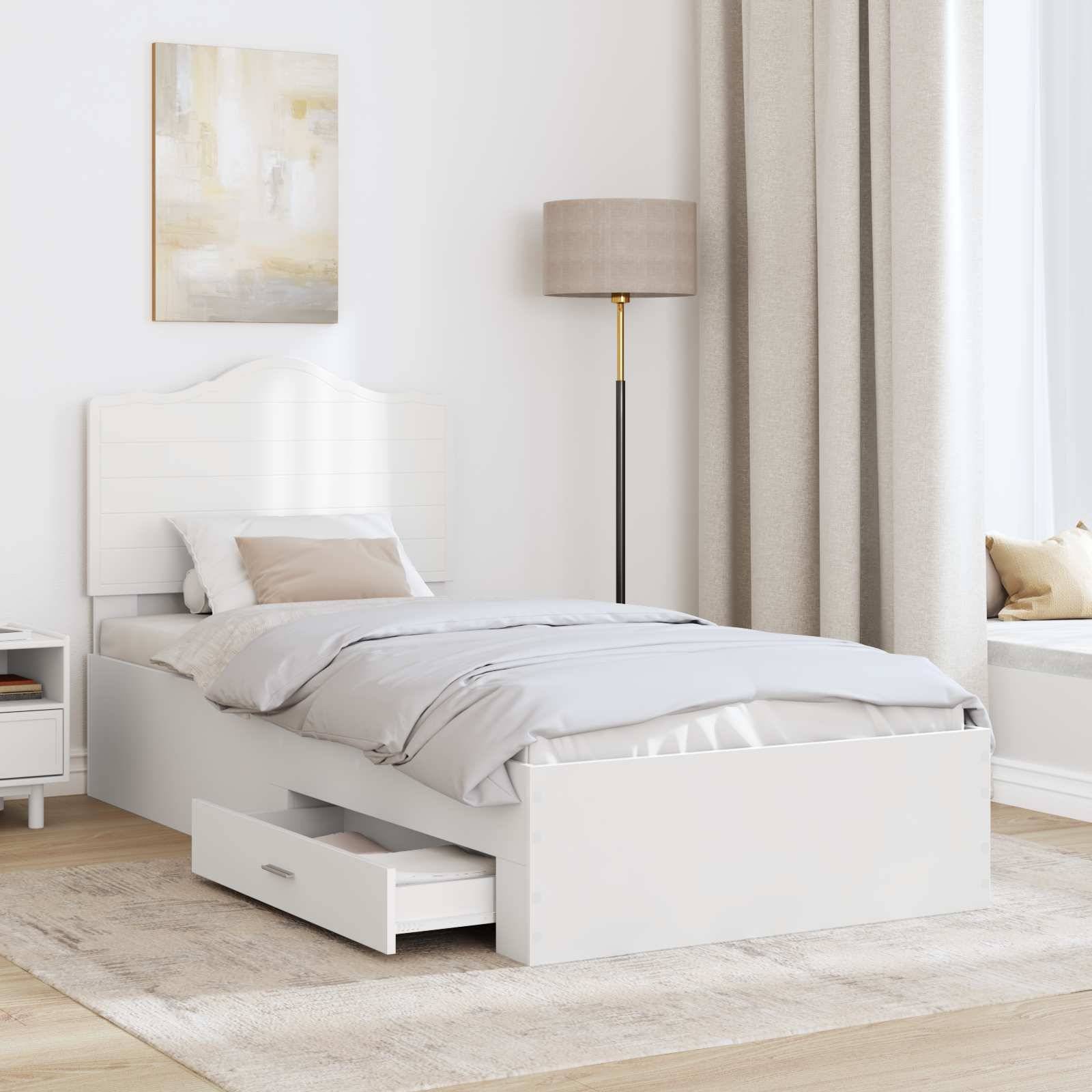 Ein modernes Schlafzimmer mit einem weißen Bett mit ausziehbarer Schublade, einer Lampe auf der rechten Seite, einer Fensterbank und beigen Vorhängen, die eine gemütliche Atmosphäre schaffen.