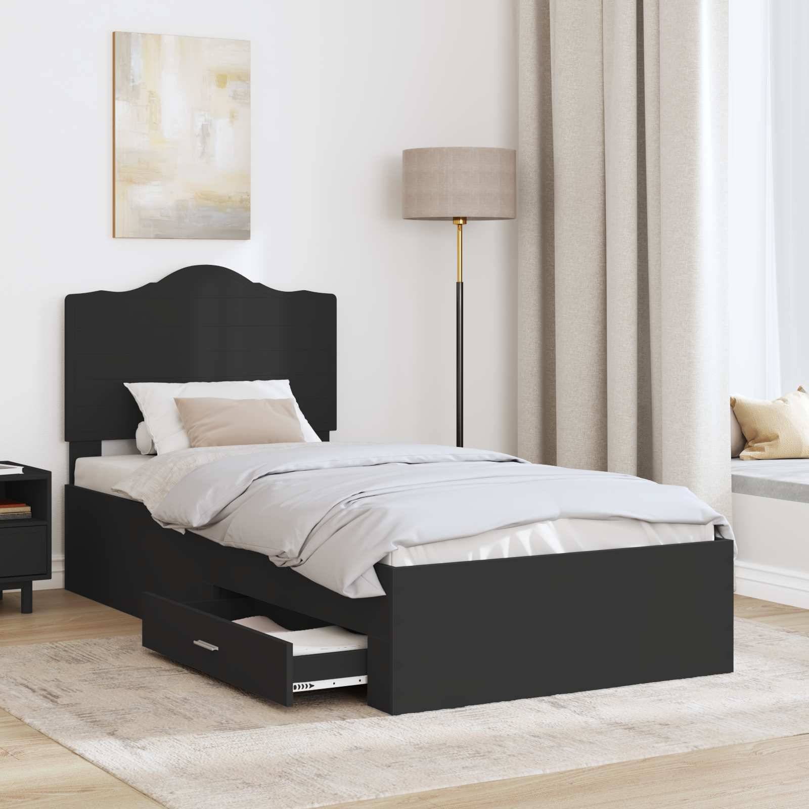 Ein modernes Schlafzimmer mit einem schwarzen Einzelbett mit Schublade darunter, einem Nachttisch mit einer Lampe und natürlichem Licht von einem Fenster.