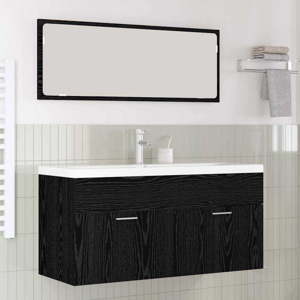 Ein modernes Badezimmer mit einem schwarzen Holzwaschtisch, weißem Waschbecken, einem großen rechteckigen Spiegel darüber und Regalen, auf denen ein Handtuch und Toilettenartikel stehen.