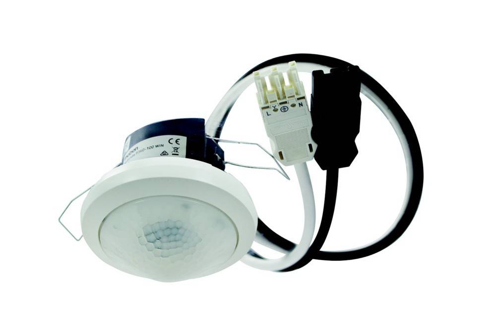 Ein kreisförmiger, weißerDeckensensor mit angeschlossener Verkabelung, der zur Bewegungserkennung konzipiert ist und wahrscheinlich für automatische Beleuchtungssysteme verwendet wird.