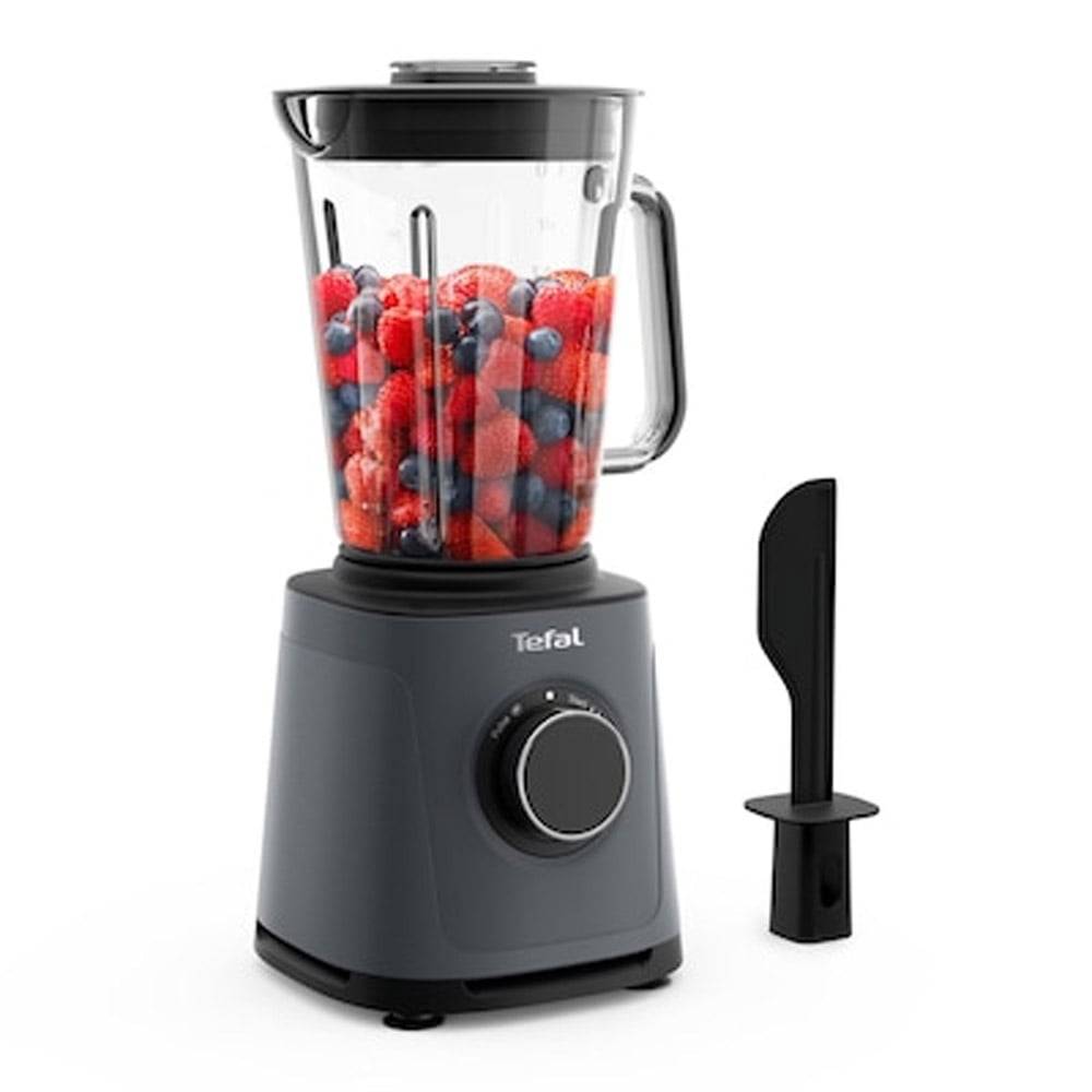 Ein schwarzer und transparenter Mixer, der eine Mischung aus Erdbeeren, Himbeeren und Blaubeeren enthält, neben einem schwarzen Pfannenwender.