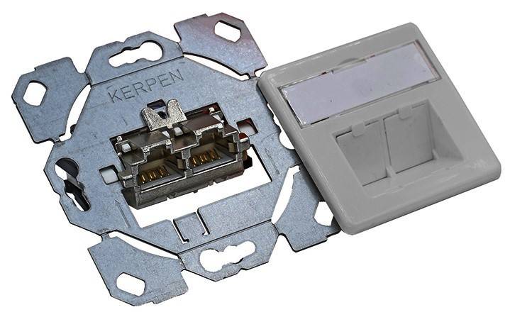 Wandmontierte Ethernet-Buchse aus Metall mit sichtbaren internen Verbindungen, daneben eine Kunststoffabdeckung, zeigt Montagebauteile für Netzwerkinfrastruktur.