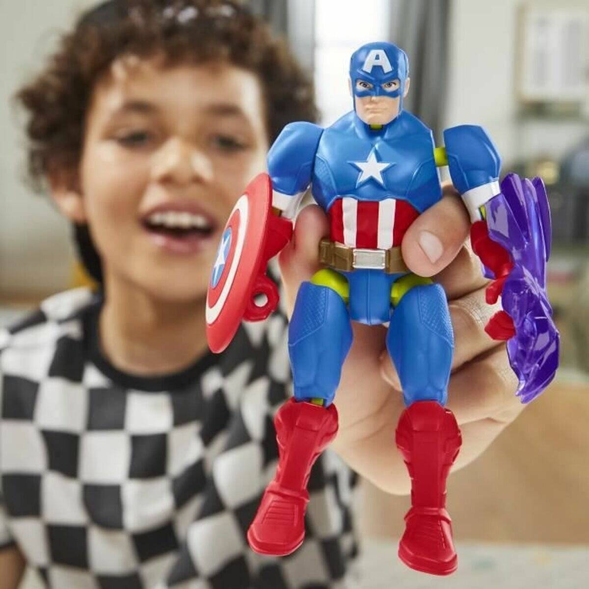 Ein Kind lächelt, während es eine Actionfigur hält, die einen Anzug mit einem Stern auf der Brust, rote Stiefel trägt und einen kreisrunden Schild in der Hand hält.