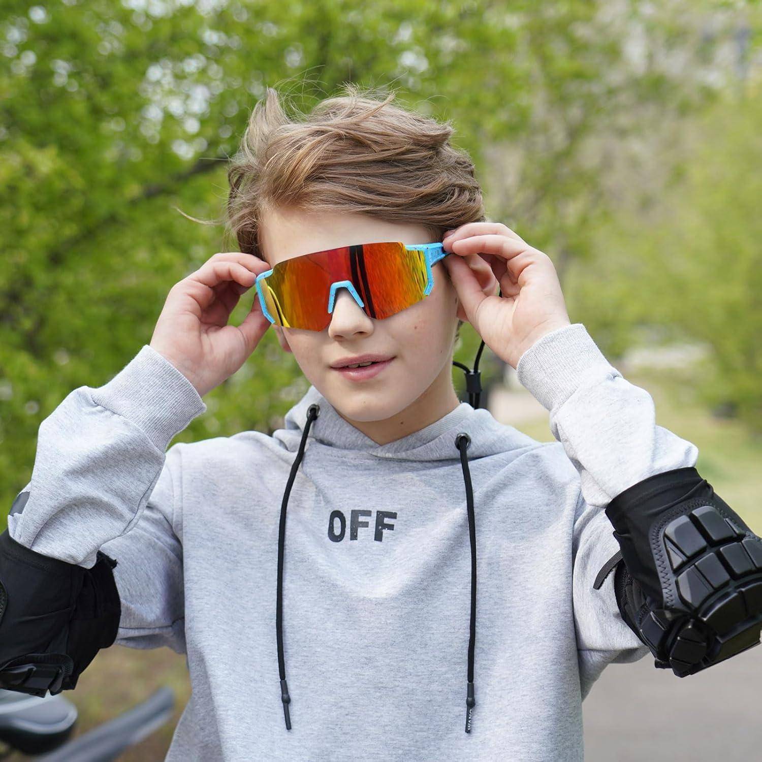 Ein Kind mit bunter Sonnenbrille, Ellbogenschonern und einem Sweatshirt mit der Aufschrift 