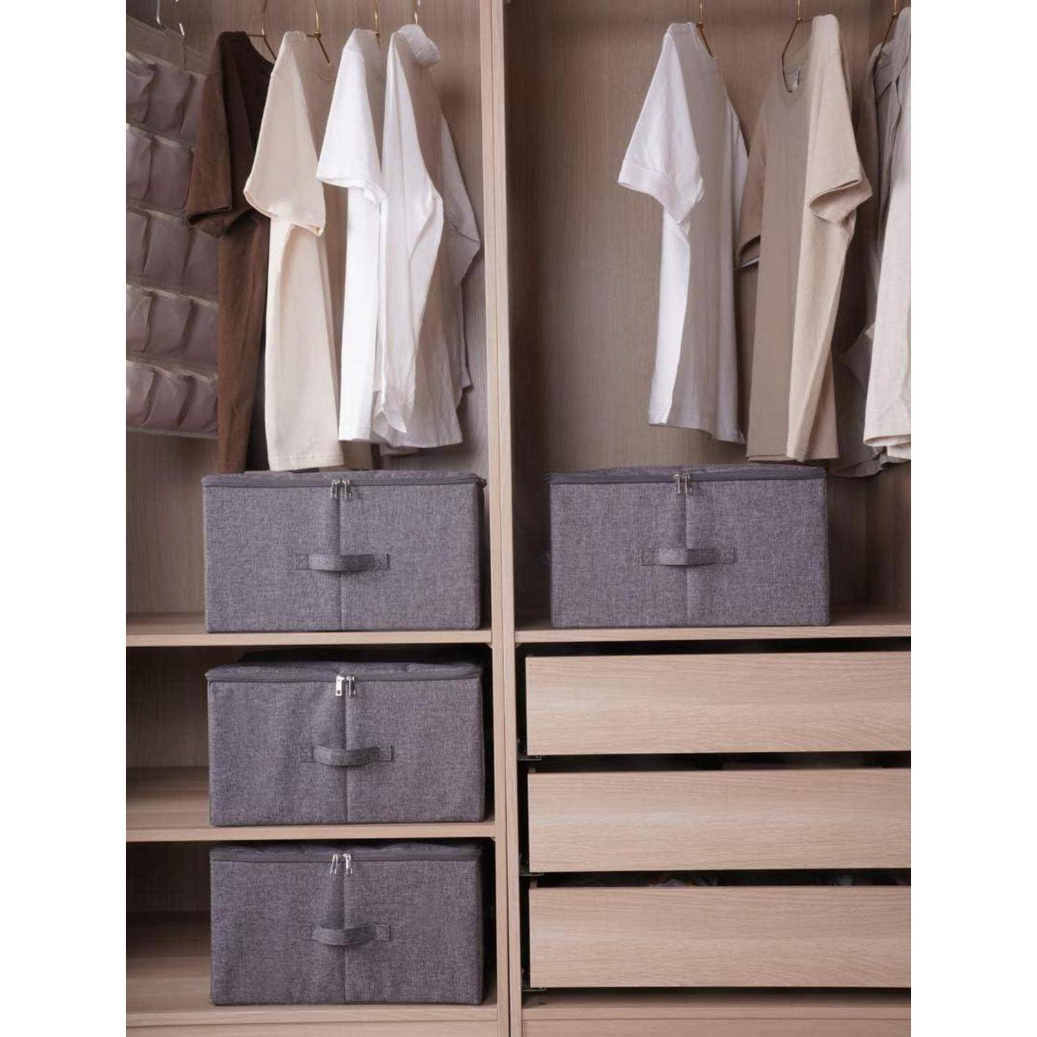 Organisierter Kleiderschrank mit beige und weißen Kleidungsstücken, die über grauen Stoffaufbewahrungsboxen und leeren Holzschubladen hängen.