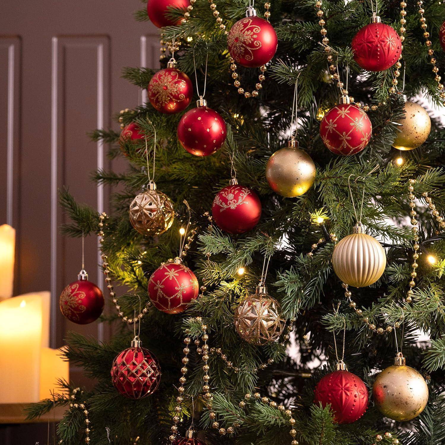 Ein mit roten und goldenen Ornamenten und Lichtern geschmückter Weihnachtsbaum ist zu sehen, während im Hintergrund Kerzen sanft glimmen.