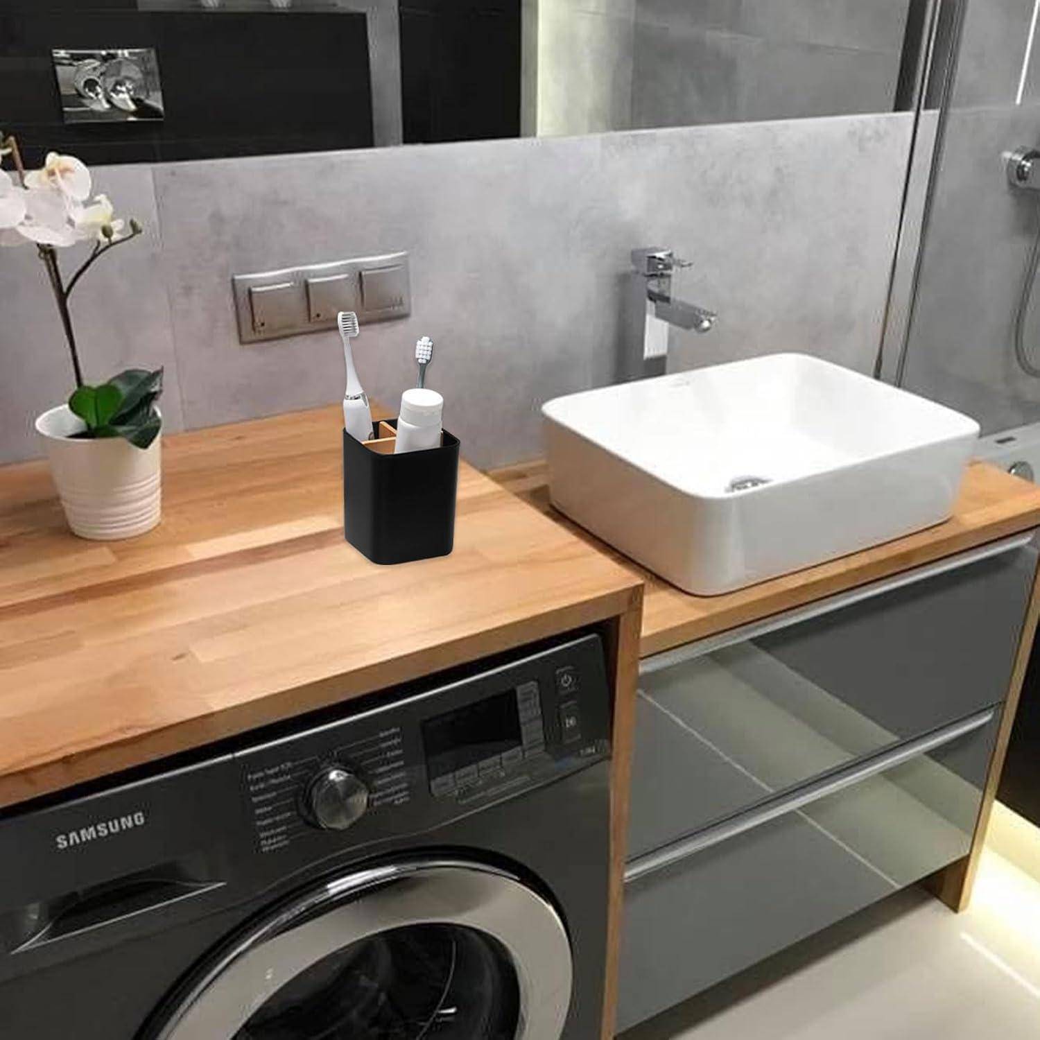 Ein modernes Badezimmer mit einer Holzarbeitsplatte, Waschbecken und Zahnbürstenhalter. Eine Waschmaschine befindet sich unterhalb der Arbeitsplatte, und eine Dusche ist sichtbar.