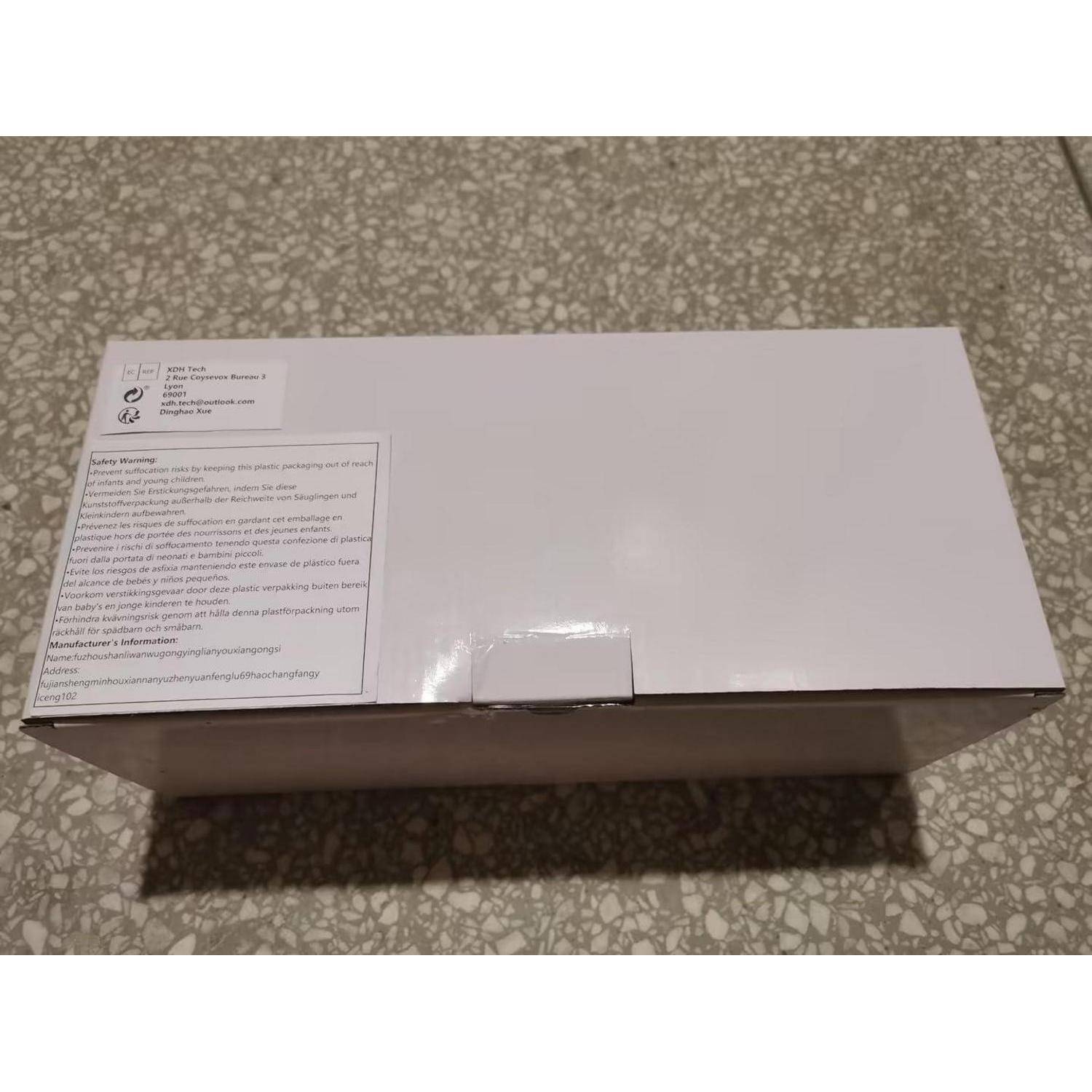 Eine weiße rechteckige Box mit einer Etikette, die Produktinformationen und Sicherheitshinweise auf einer gesprenkelten Oberfläche zeigt.