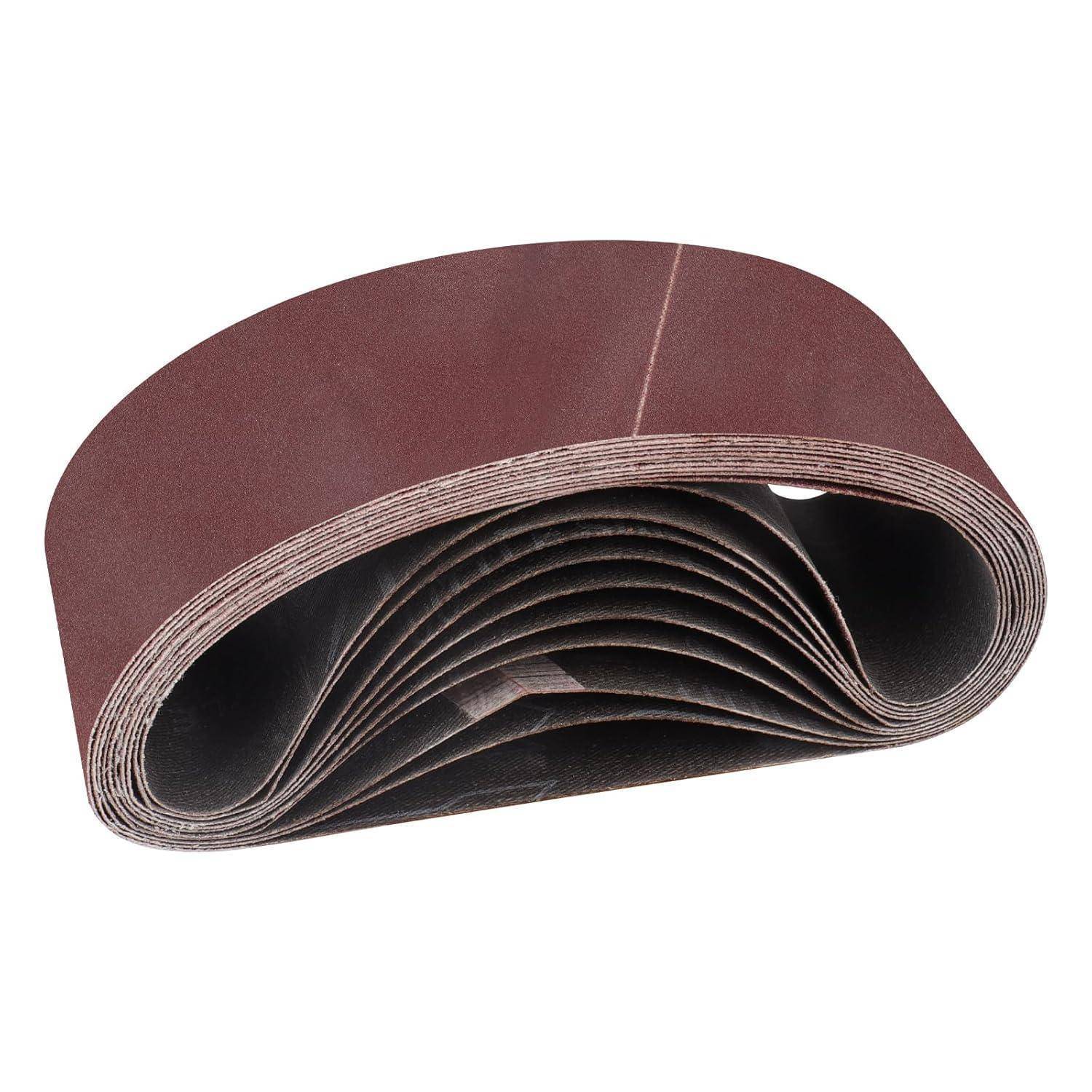 Ein Stapel brauner, gefalteter Schleifbänder, in Schleifenform angeordnet, die zum Glätten von Oberflächen in der Holz- oder Metallverarbeitung verwendet werden.