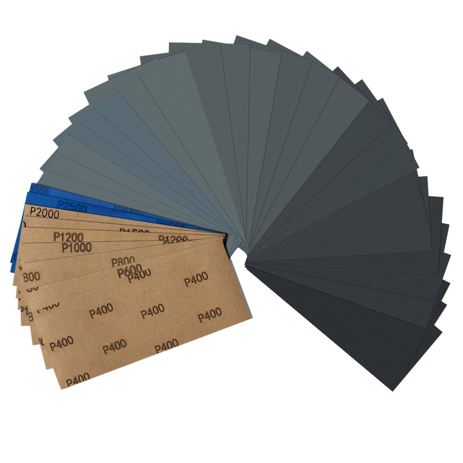 Eine fächerförmige Anordnung von Schleifpapierblättern in verschiedenen Körnungen, von P400 bis P2000, die eine Palette von Texturmöglichkeiten von grob bis fein zeigt.