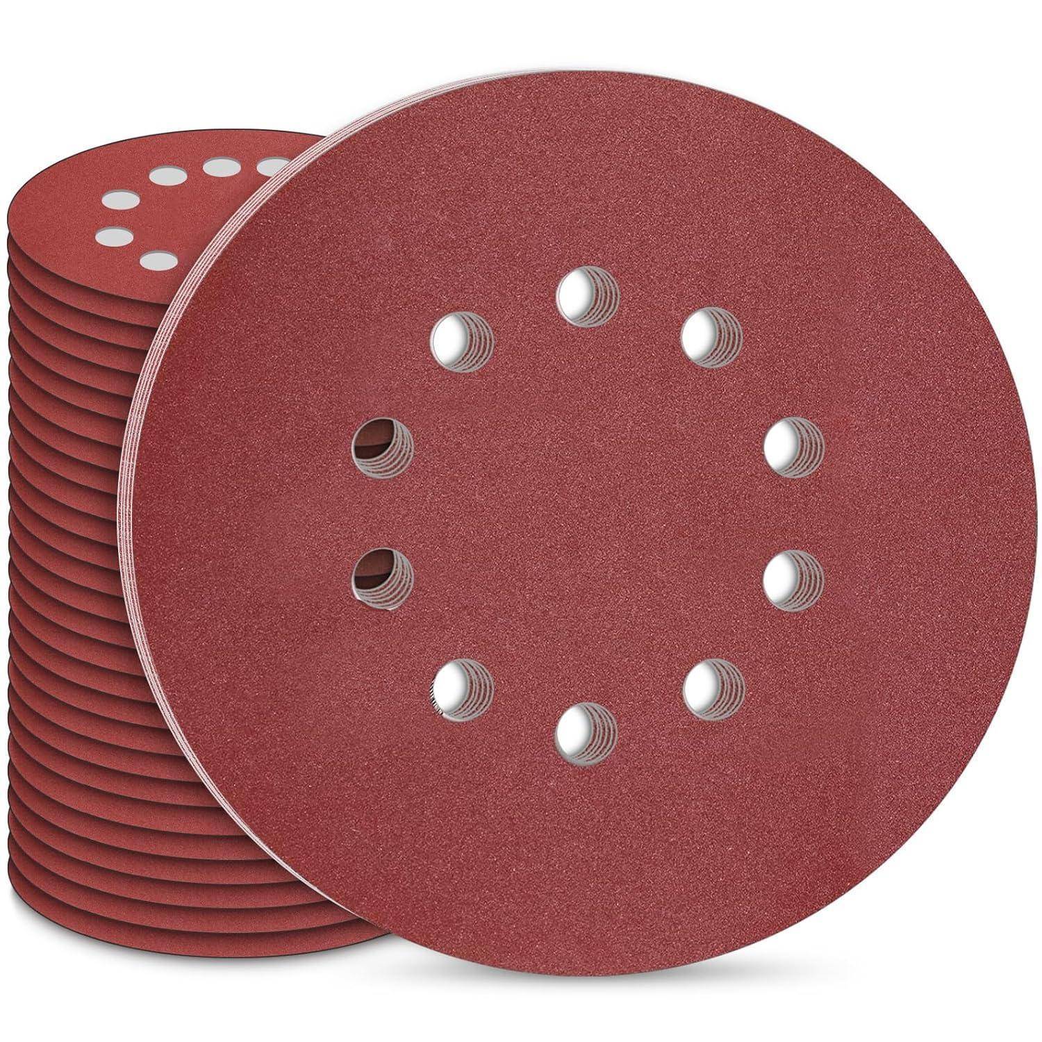 Ein Stapel roter, kreisförmiger Schleifscheiben aus Schmirgelpapier mit Löchern in der Mitte, die zum Schleifen von Oberflächen verwendet werden.