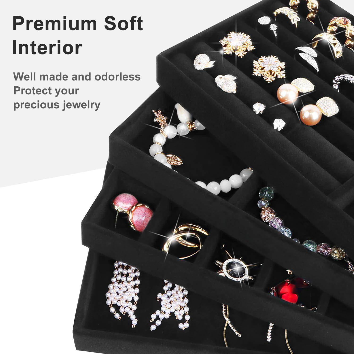 Schwarzer Schmuckorganizer mit mehreren Fächern, auf dem verschiedene Schmuckstücke ausgestellt sind. Text lautet 'Premium Soft Interior'.