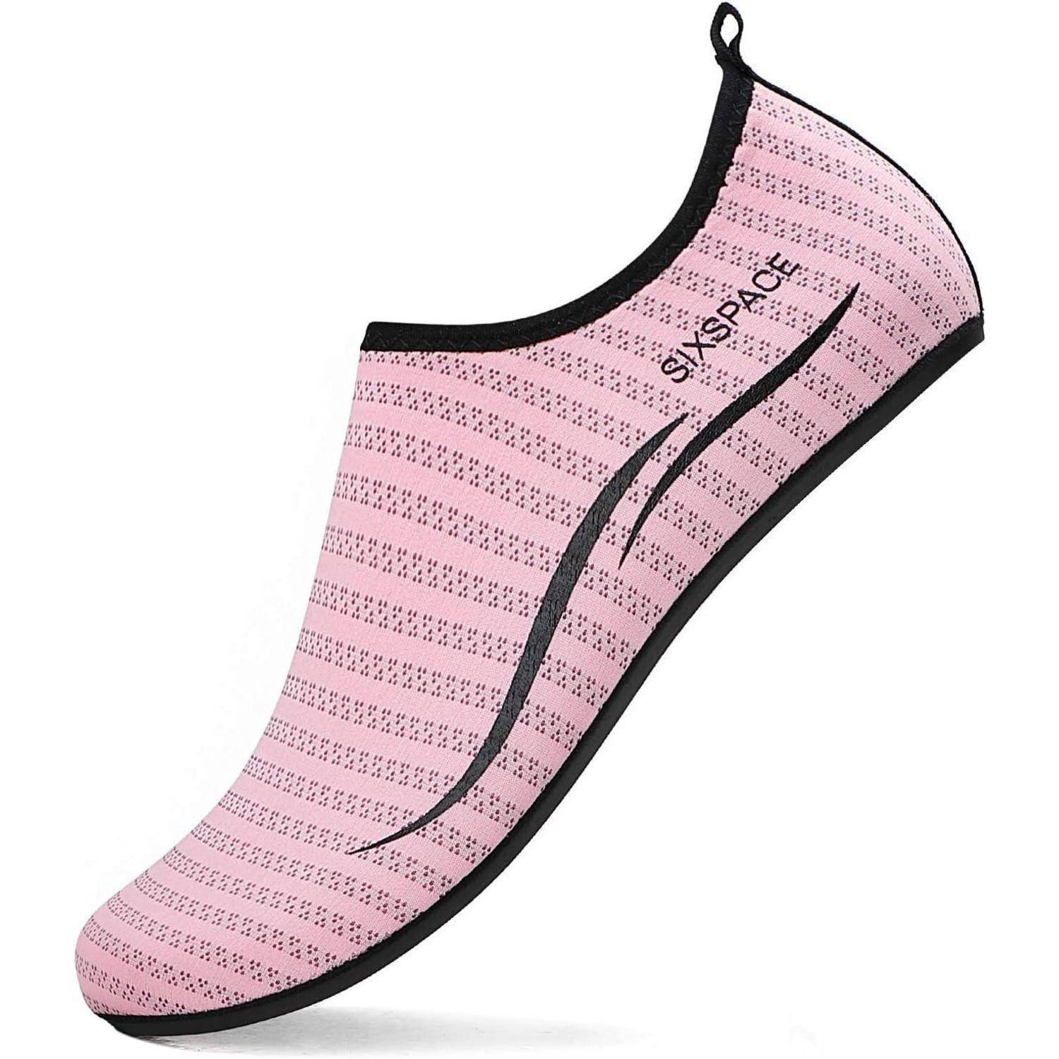 Ein rosa Slip-on-Wasserschuh mit schwarzen Sohlen und dünnen schwarzen Streifen, entworfen für Schwimmen oder Strand-Aktivitäten.