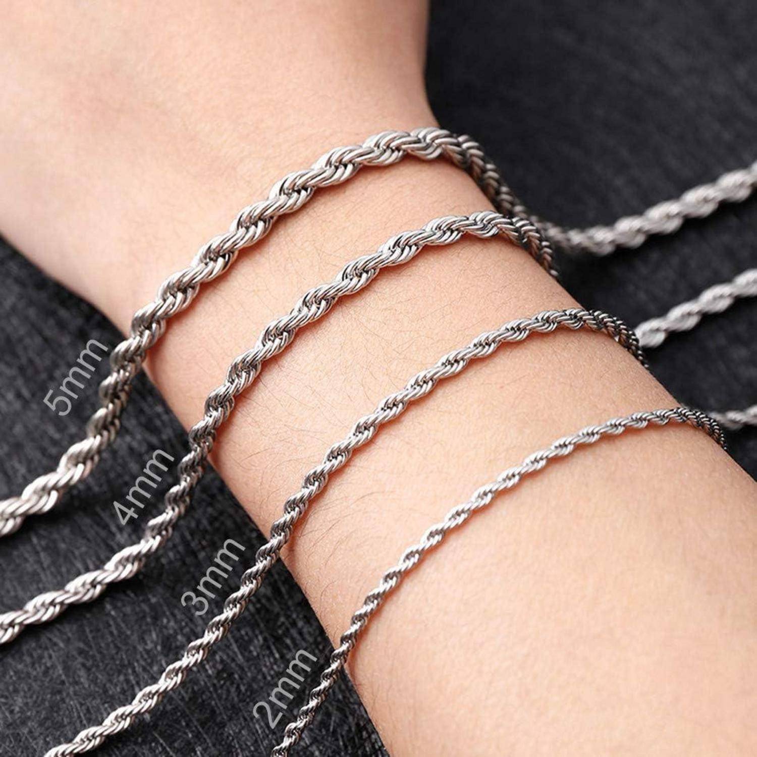 Nahaufnahme eines Handgelenks, an dem vier silberne Seilketten in unterschiedlichen Stärken, von 2 mm bis 5 mm beschriftet, die Größenunterschiede veranschaulichen.