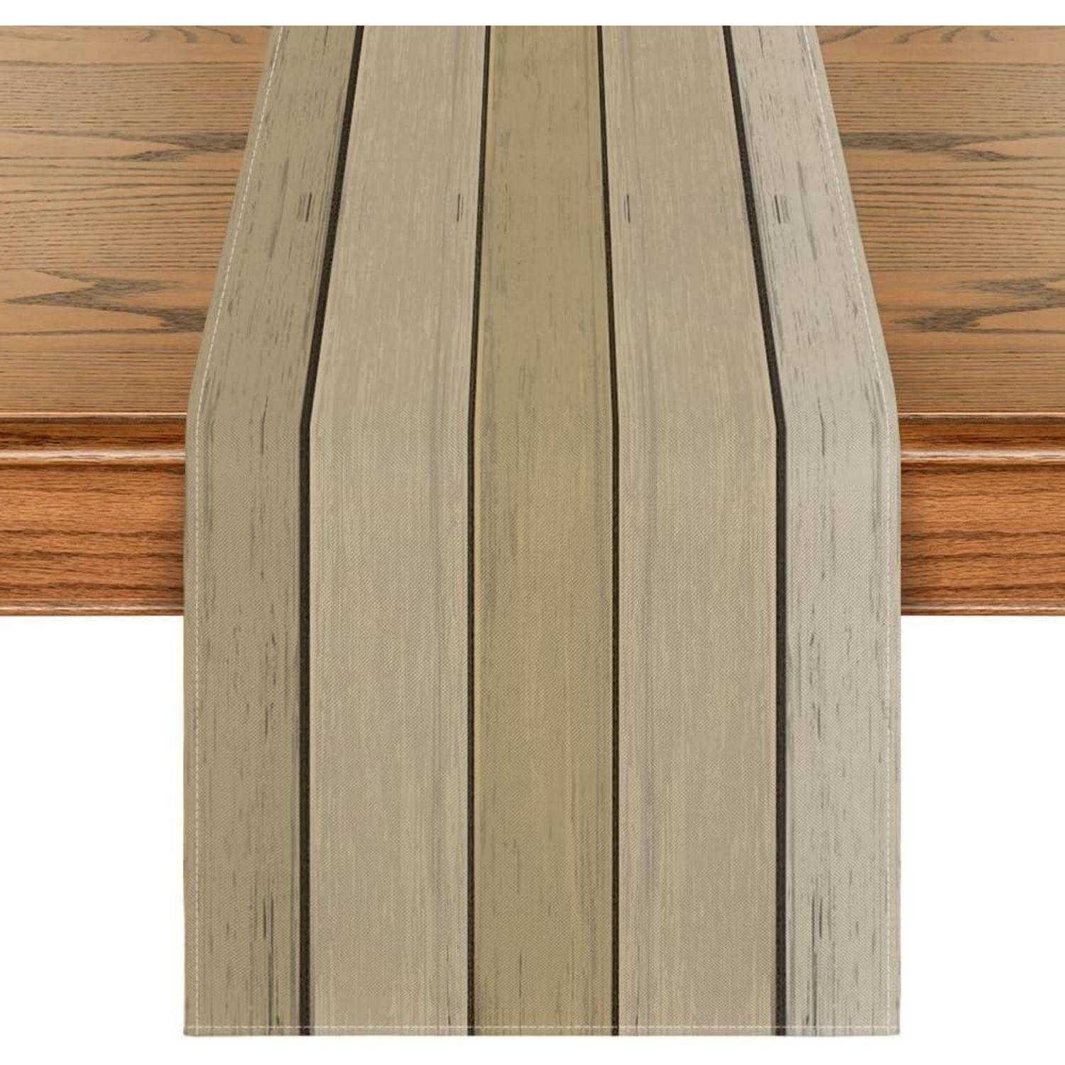 Ein Holztisch mit einem beigen gestreiften Tischläufer, der in der Mitte ausgelegt ist und ein minimalistisches und natürliches Dekorthema unterstreicht.