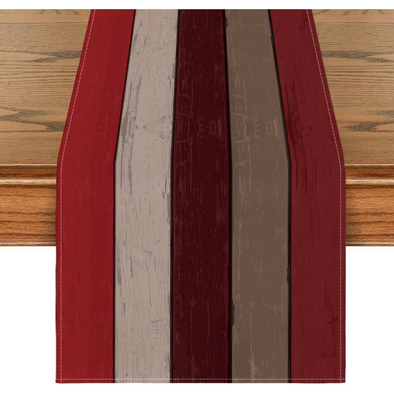 Ein Holztisch ist mit einem vertikalen gestreiften Tischläufer versehen, der abwechselnd rote und braune Töne aufweist und so einen warmen und rustikalen Dekoration-Akzent setzt.