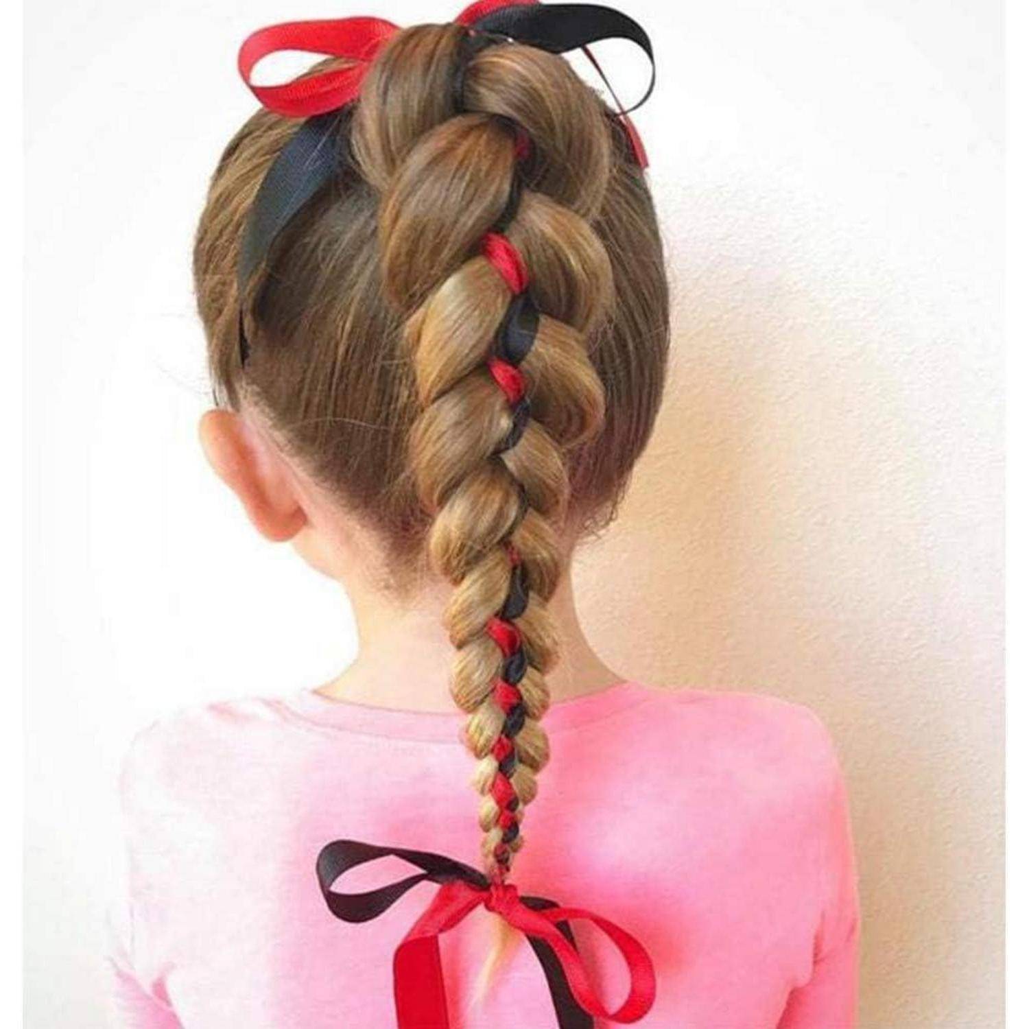 Ein junges Mädchen mit einem geflochtenen Zopf, geschmückt mit schwarzen und roten Bändern. Sie trägt ein rosa Top mit schwarzen und roten Bändern auf der Rückseite.