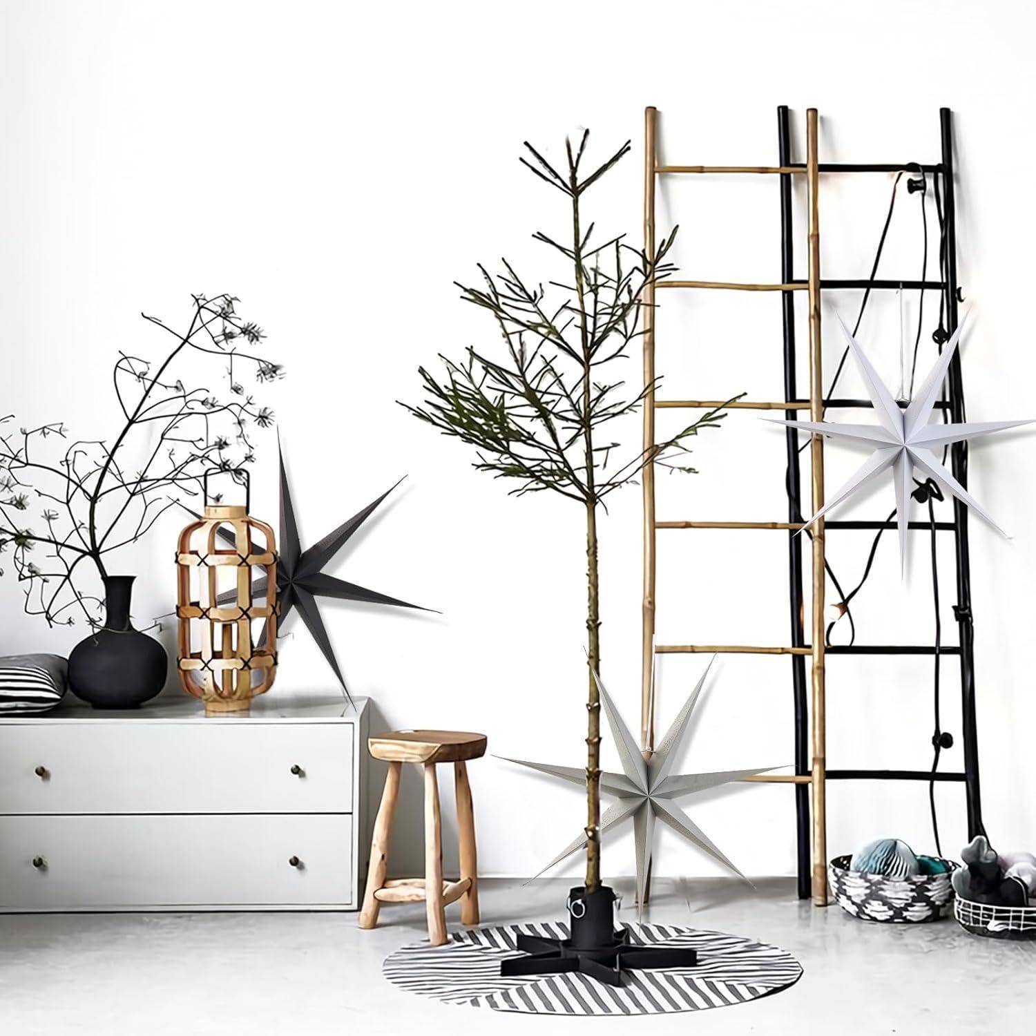 Ein minimalistisches Interieur mit Topfpflanzen, einer Holzleiter, dekorativen Sternen und einem weißen Schubladenschrank vor einer weißen Wand.
