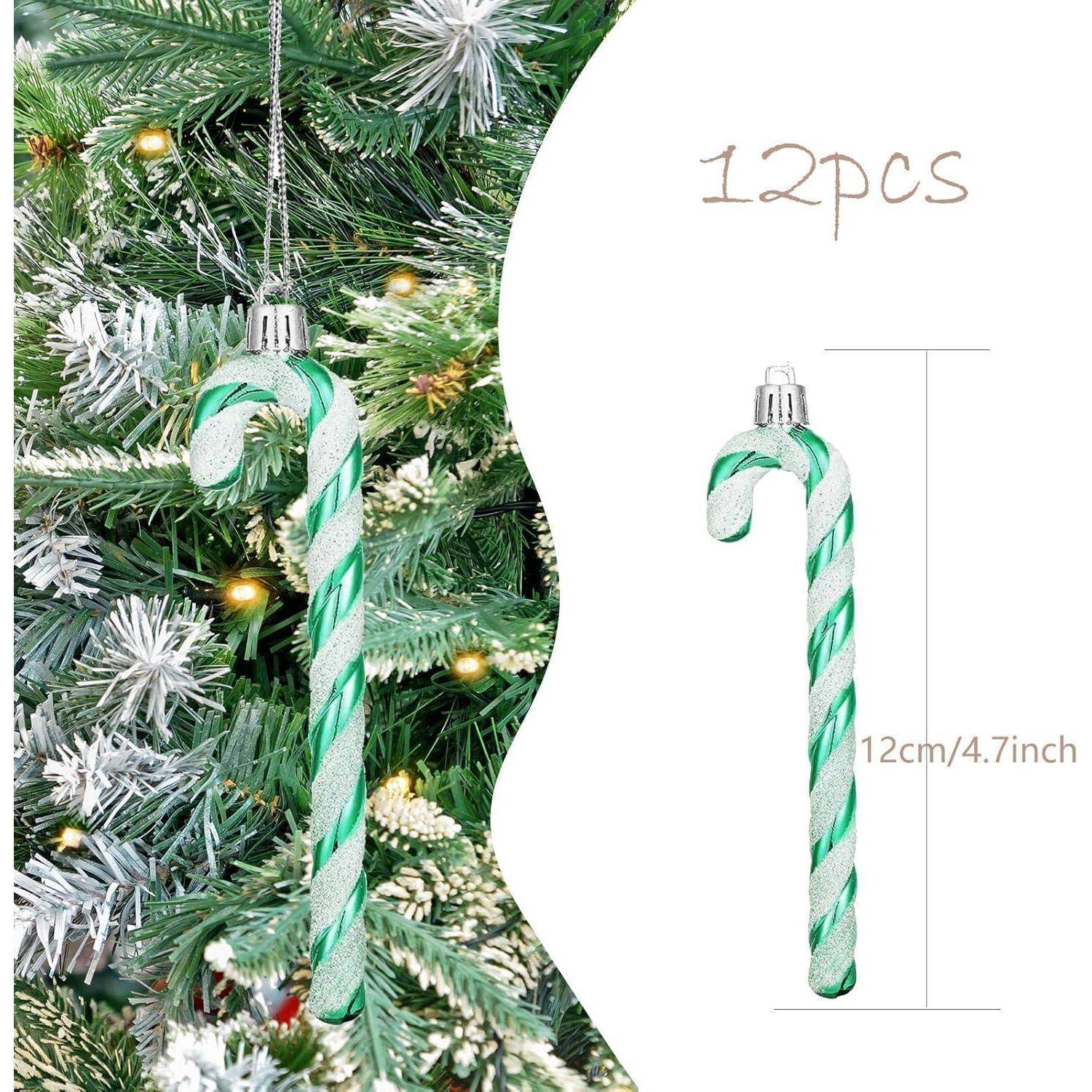 Grüne und weiße Zuckerstangen-Weihnachtsbaumschmuck mit 12 Stück, jeweils 12 cm/4,7 Zoll lang, die an einem Baum mit schneebedeckten Zweigen hängen.