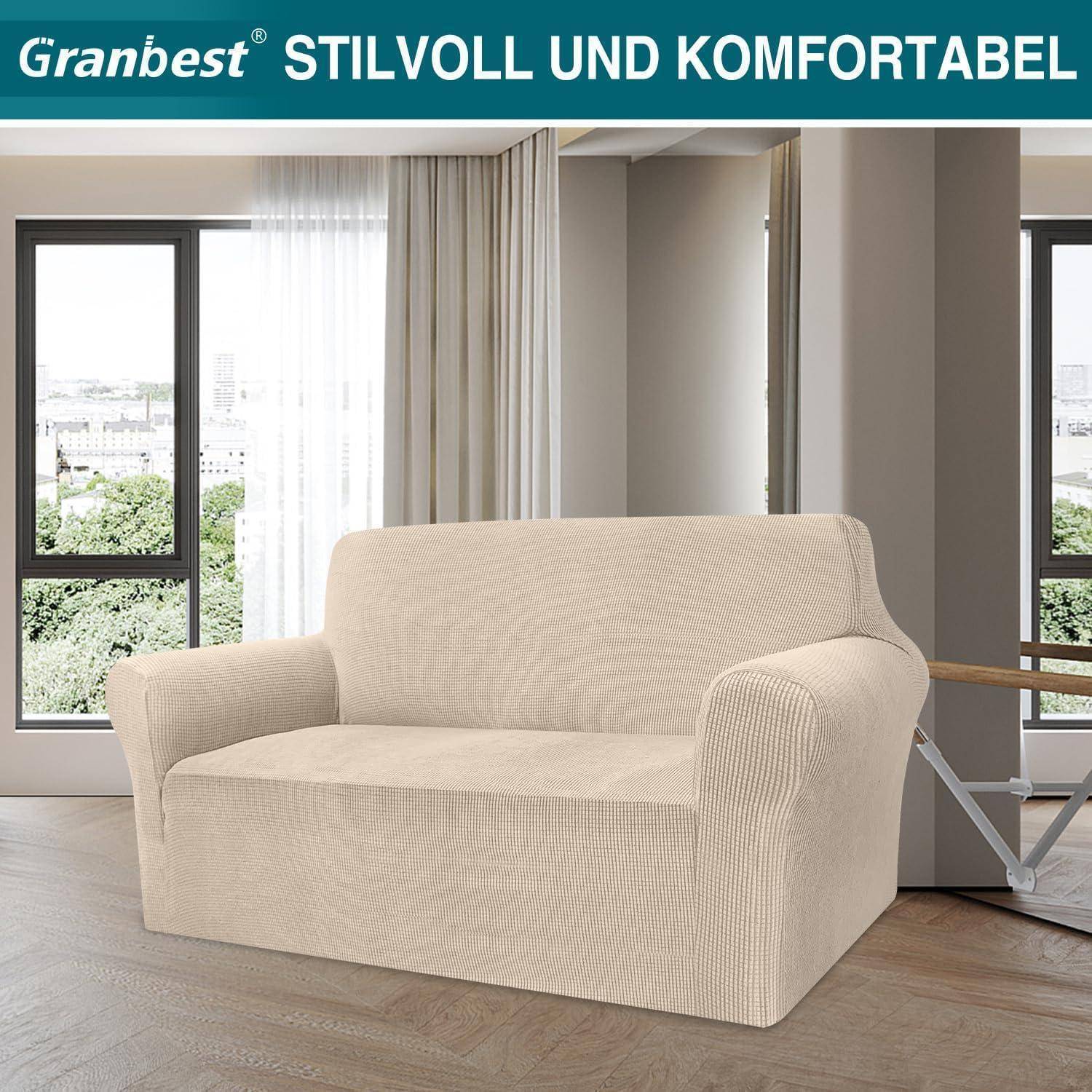 Ein beige Sofa mit einem strukturierten Bezug in einer modernen Wohnzimmerumgebung mit großen Fenstern. Text liest sich: „STILVOLL UND KOMFORTABEL