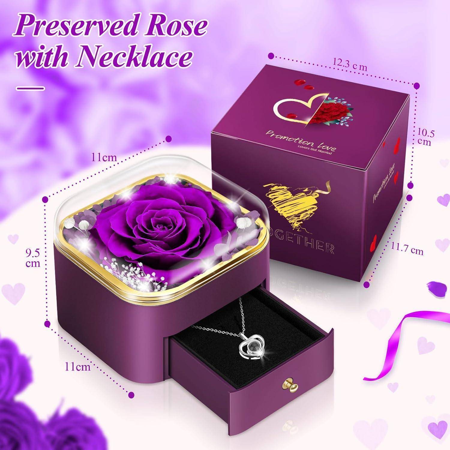 Violette Geschenkbox mit einer konservierten Rose oben drauf. Enthält eine Halskette in einer Schublade. Abmessungen: 11cm x 11cm. Text: 'Konservierte Rose mit Halskette'.