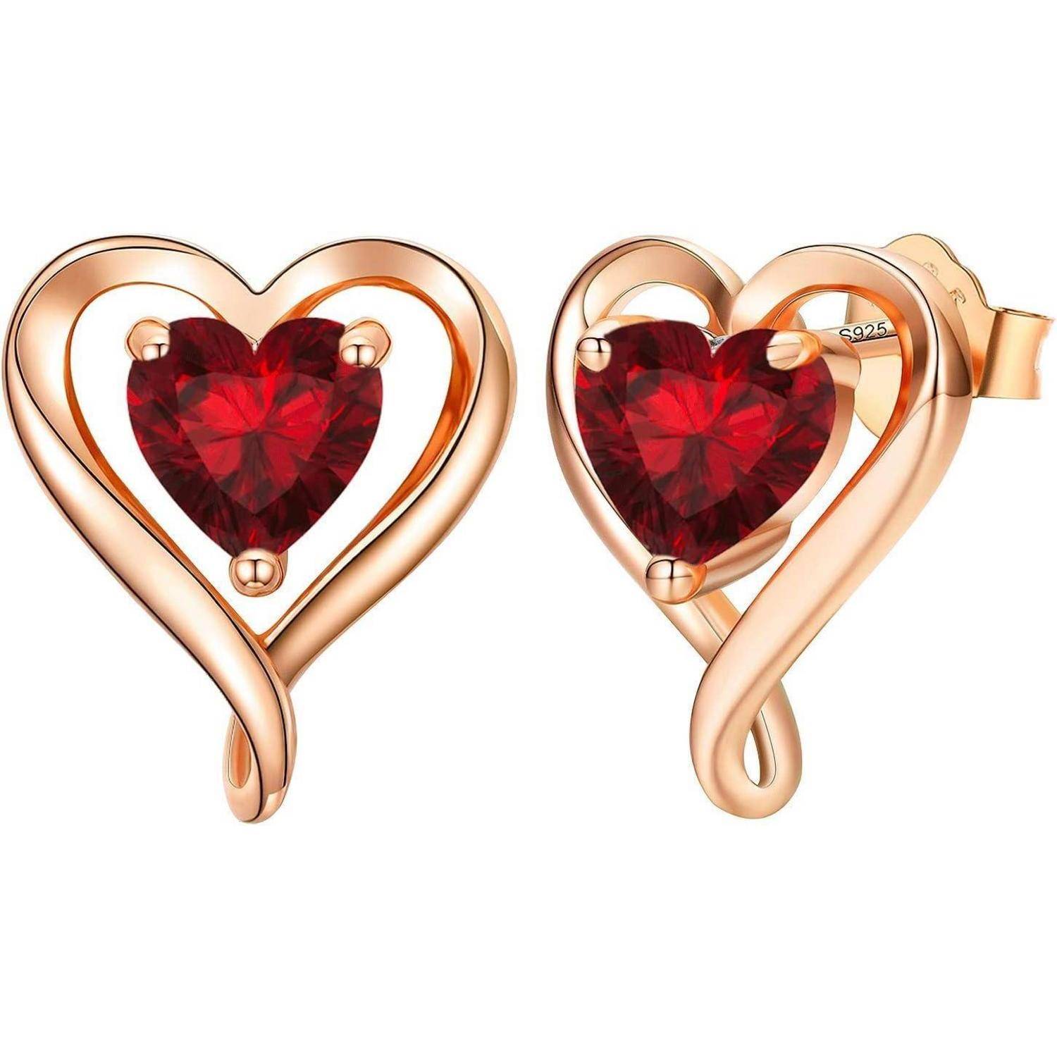 Herzförmige Ohrringe aus Roségold mit zentralen roten Edelsteinen, die Liebe und Eleganz symbolisieren.