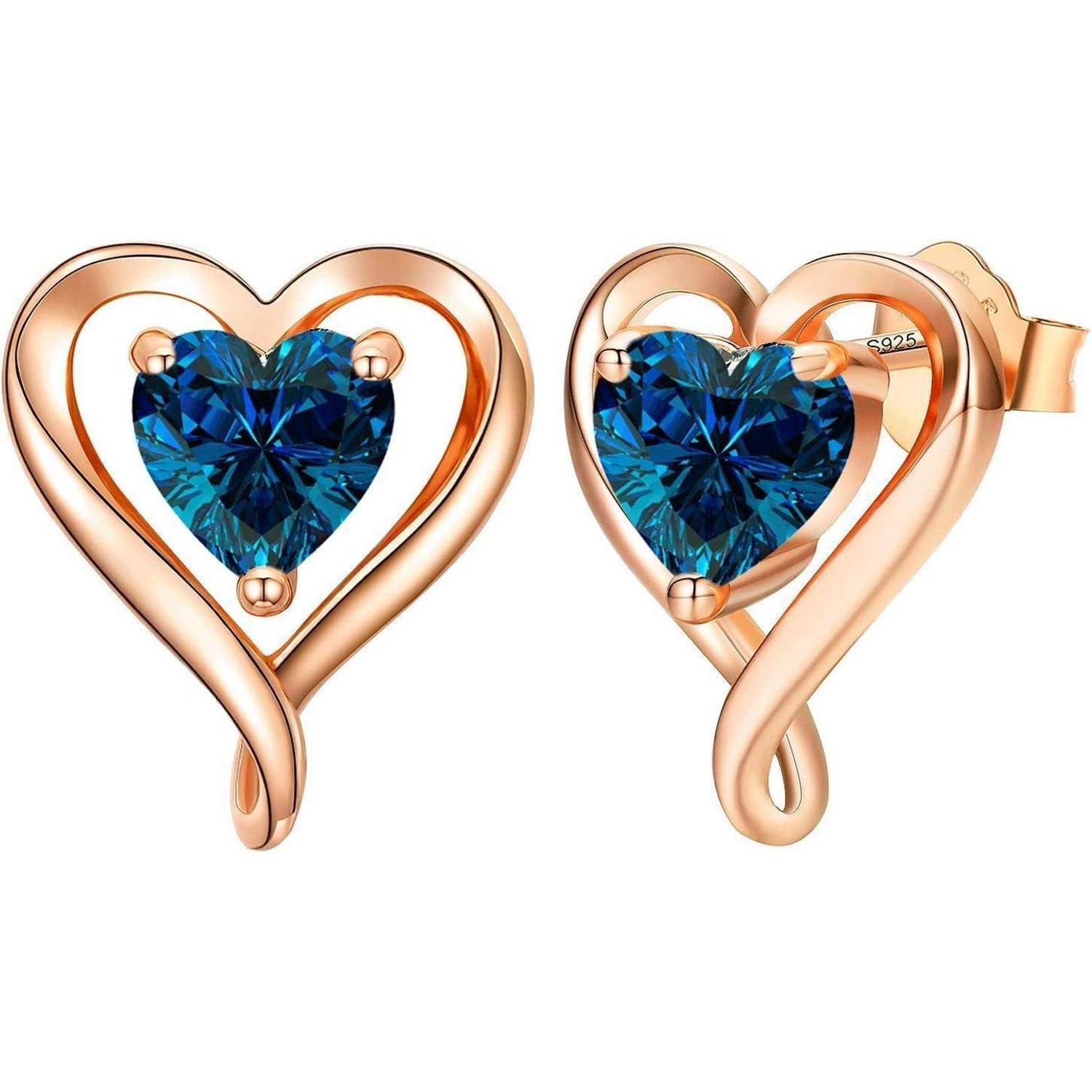Herzförmige Goldohrringe mit blauen Edelsteinen in der Mitte, die ein verschlungenes Design aufweisen und einen eleganten und romantischen Eindruck vermitteln.