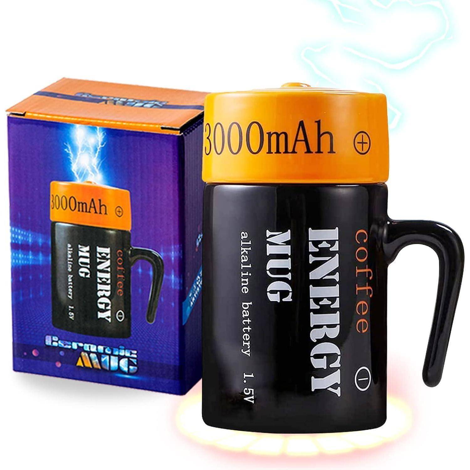 Schwarze Tasse, gestaltet wie eine Batterie, mit '3000mAh' und 'ENERGY' beschriftet. Der Hintergrund zeigt eine Produktverpackung mit ähnlichem Design.