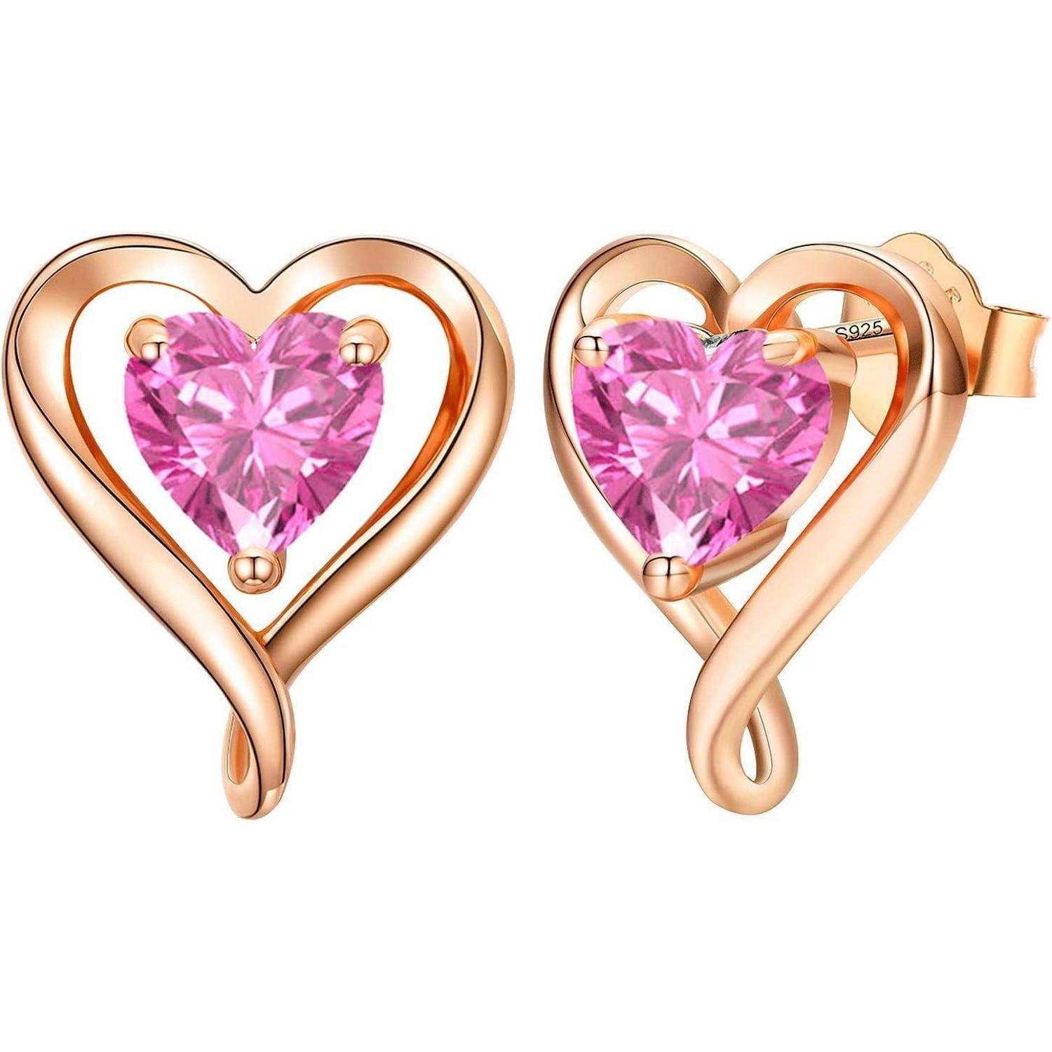 Herzförmige Ohrringe mit Roségold-Oberfläche, die pinke Edelsteine in der Mitte aufweisen.