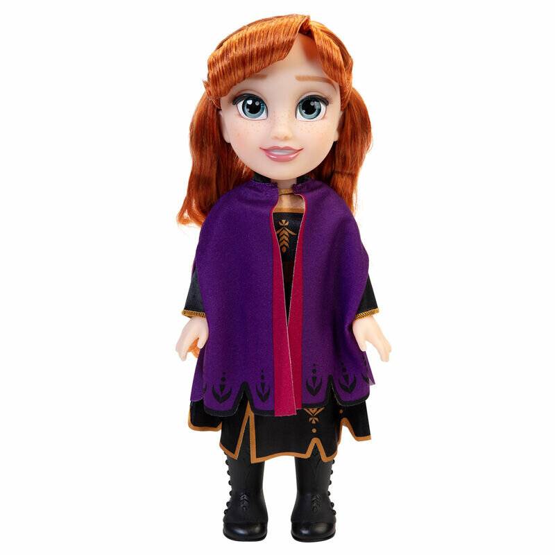 Eine Puppe mit roten Haaren, die einen lila Umhang, ein schwarzes Kleid und schwarze Stiefel trägt, steht aufrecht vor einem weißen Hintergrund.