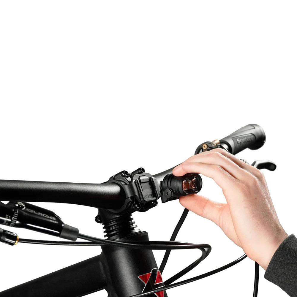 Eine Hand justiert einen Fahrrad-Schalthebel am Lenker und veranschaulicht damit die Funktionalität des Gangwechsels.