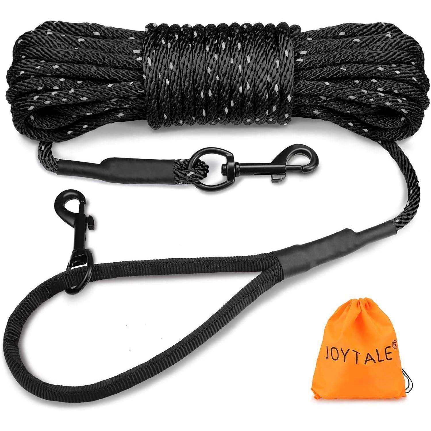 Eine aufgewickelte schwarze Hundeleine mit reflektierenden Fäden und zwei robusten Karabinern wird neben einem orangefarbenen Beutel mit der Aufschrift „JOYTALE