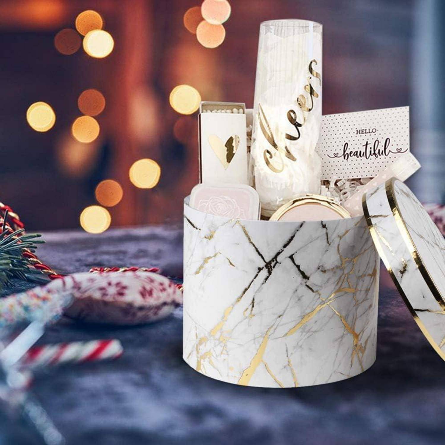 Eine Geschenkbox aus Marmor mit einem goldenen Streifen, die eine Kerze mit der Aufschrift 