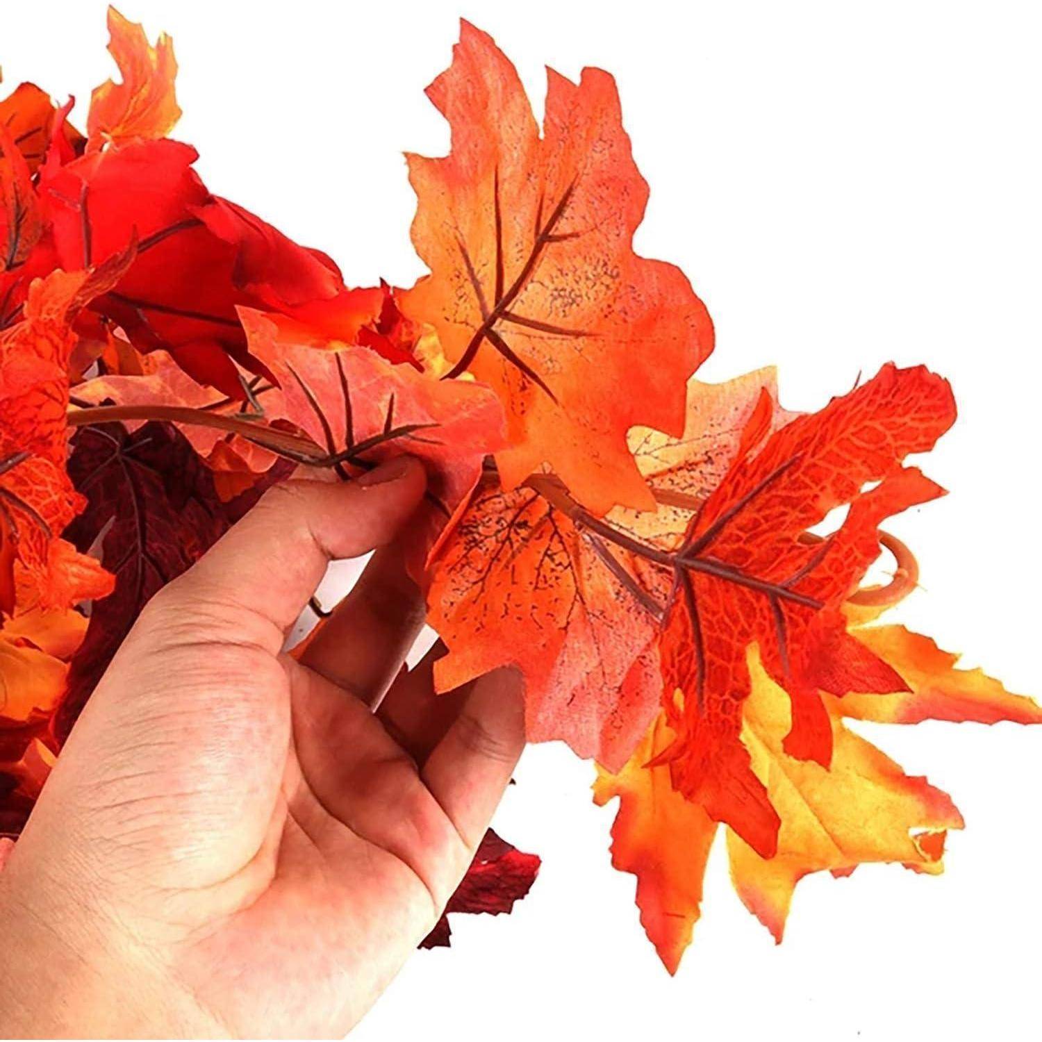 Eine Hand hält eine Sammlung lebhafter Herbstblätter in Tönen von Orange und Rot und zeigt die Textur und Farben des Herbstlaubes.