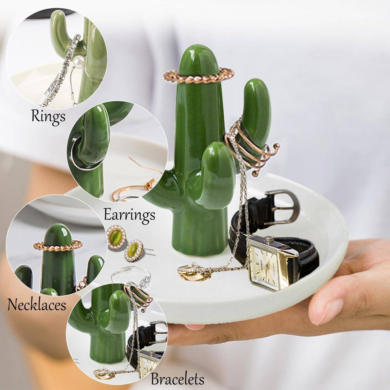Eine Hand, die einen kaktusförmigen Schmuckhalter hält, auf dem Ringe, Ohrringe, Halsketten und Armbänder ausgestellt sind.