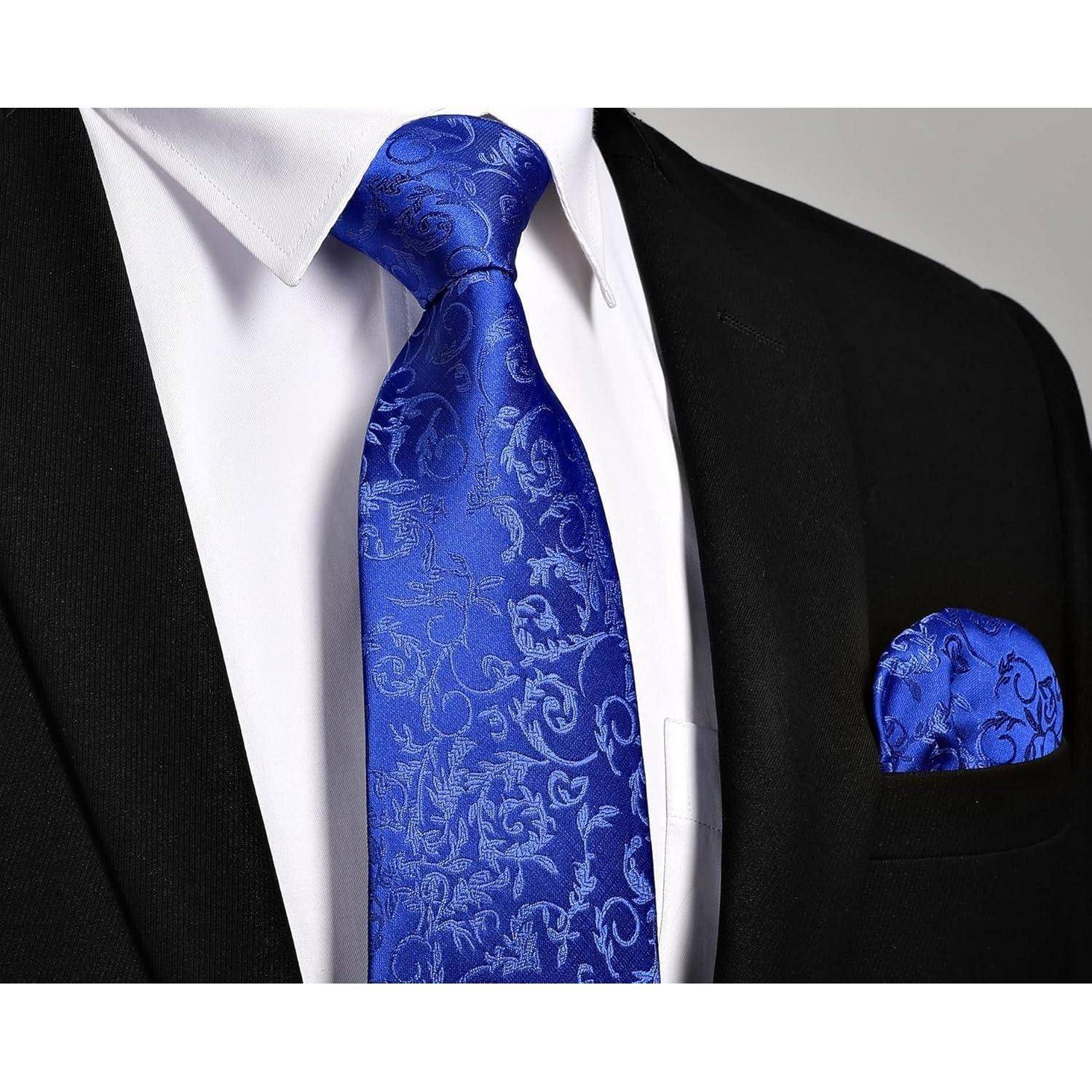 Eine Nahaufnahme einer Person, die ein weißes Hemd, einen schwarzen Anzug und eine lebendige blaue gemusterte Krawatte mit einem passenden Einstecktuch trägt.