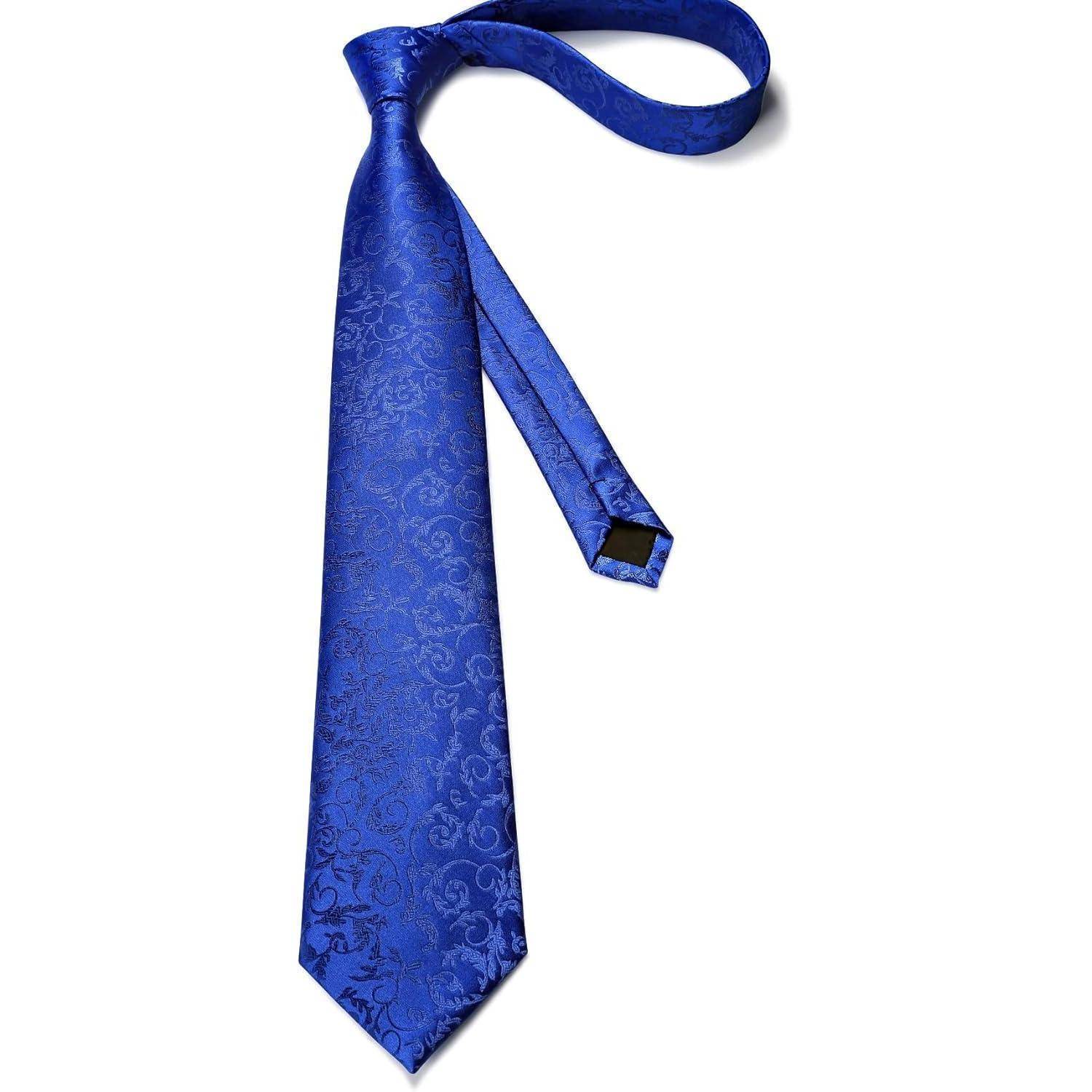 Eine blaue Seidenkrawatte mit einem komplexen Blumenmuster-Design, flach ausgebreitet mit dem schmalen Ende zurückgeschlauft, die ihre elegante Textur zur Geltung bringt.