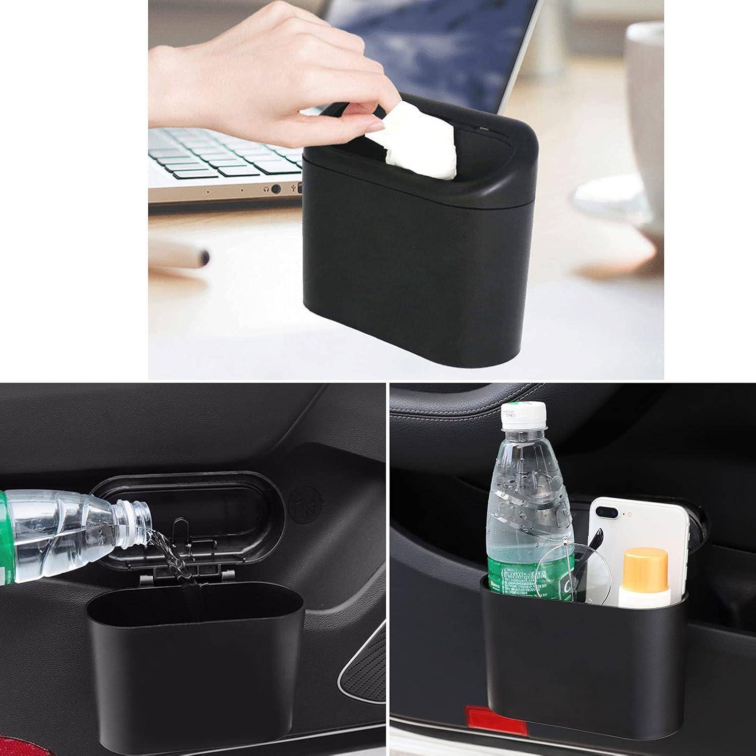 Hand wischt den Deckel eines kleinen schwarzen Aufbewahrungsbehälters ab, während ein Laptop in der Nähe liegt. In der Türtasche des Autos befinden sich der Behälter, eine Wasserflasche und ein Telefon.