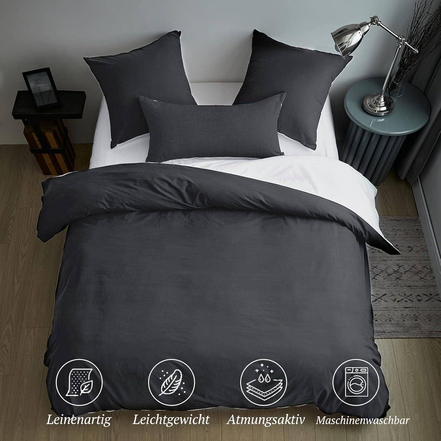 Ein ordentlich gemachtes Bett mit dunkelgrauer Bettwäsche, ausgestattet mit drei Kissen und einer Decke. Icons unterhalb zeigen seine leinenähnliche Textur, Leichtigkeit, Atmungsaktivität und Maschinenwäsche-Eigenschaften.