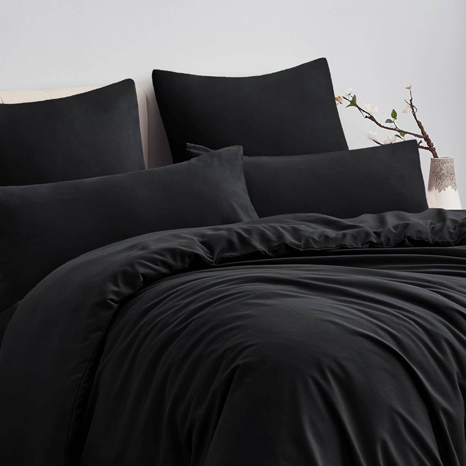 Ein ordentlich gemachtes Bett mit glatter schwarzer Bettwäsche, einschließlich Kissen, Decken und einem Spannbetttuch, in einem minimalistischen Raumambiente.