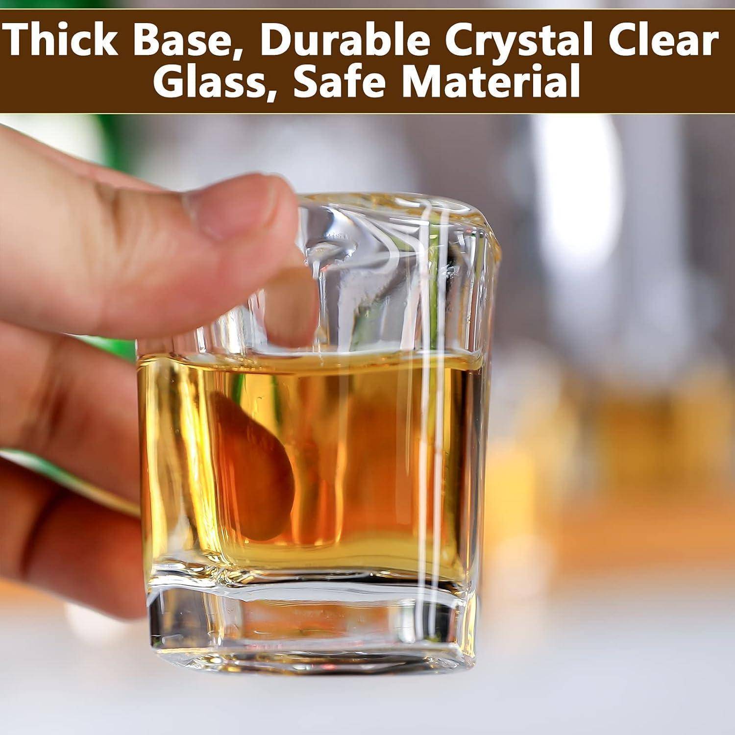 Eine Hand hält ein kurzes, dickbasiges Glas gefüllt mit bernsteinfarbener Flüssigkeit. Der Text lautet: „Dicke Basis, haltbares kristallklares Glas, sicheres Material.