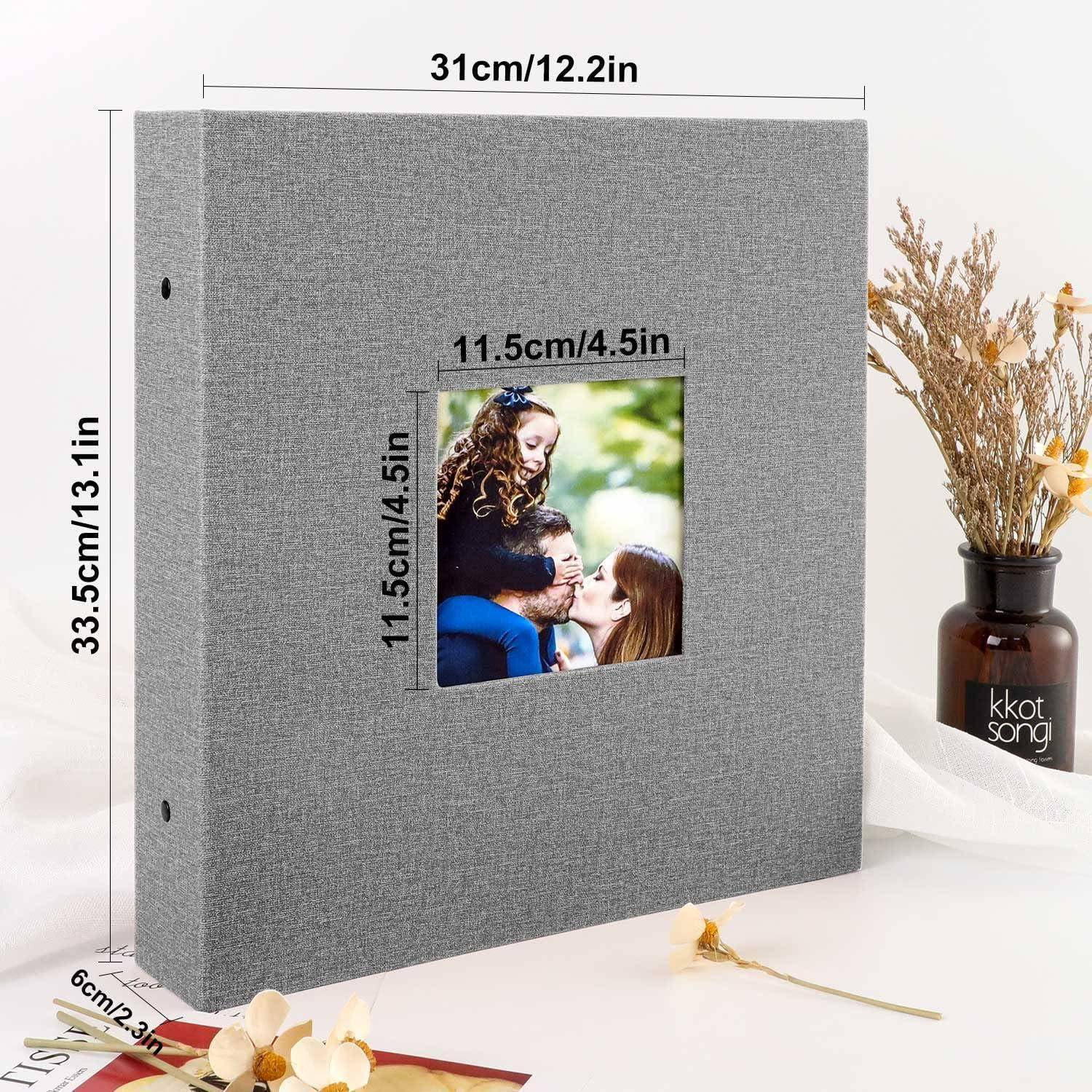 Graues Fotoalbum mit einem Fenster, das ein Familienfoto zeigt, mit den Maßen 31 cm x 33,5 cm. Vase mit Blumen daneben auf einem Tisch.