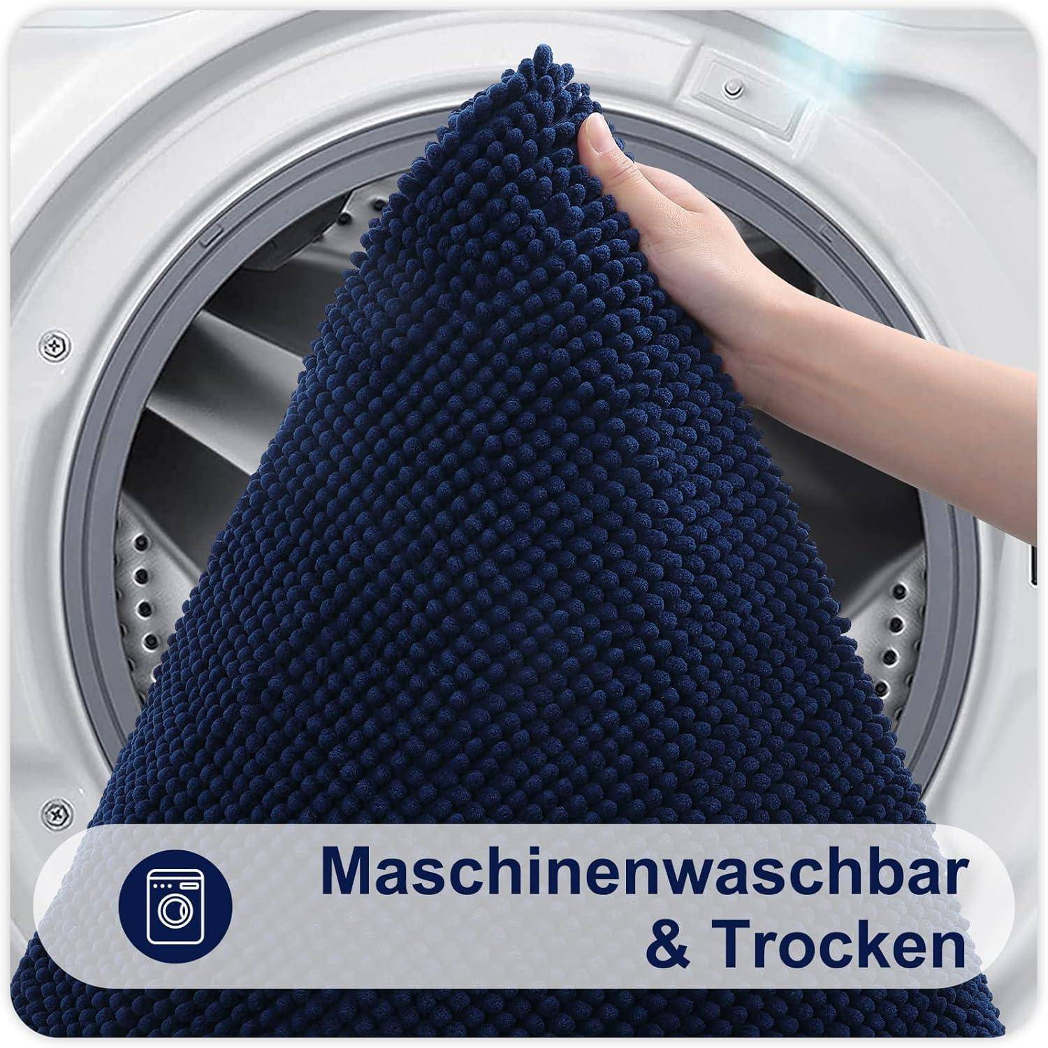 Eine Hand legt eine dunkelblau strukturierte Matte in eine Waschmaschine. Der Text lautet ‚Maschinenwaschbar & Trocken', was darauf hindeutet, dass sie maschinell waschbar ist.