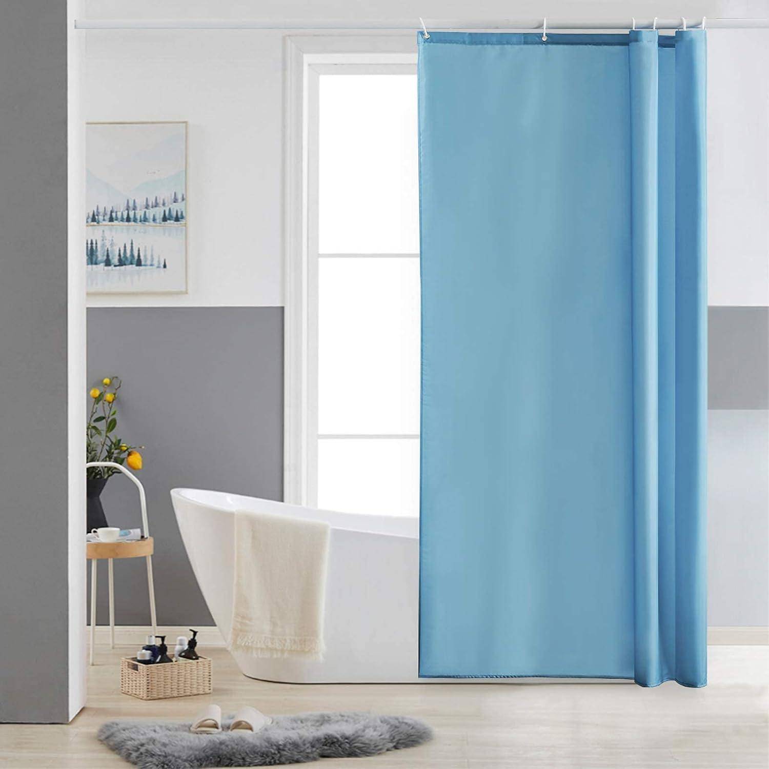 Ein modernes Badezimmer mit einer freistehenden weißen Badewanne, blauem Duschvorhang und minimalistischer Einrichtung. Ein kleines Regal beherbergt Pflanzen und Toilettenartikel.