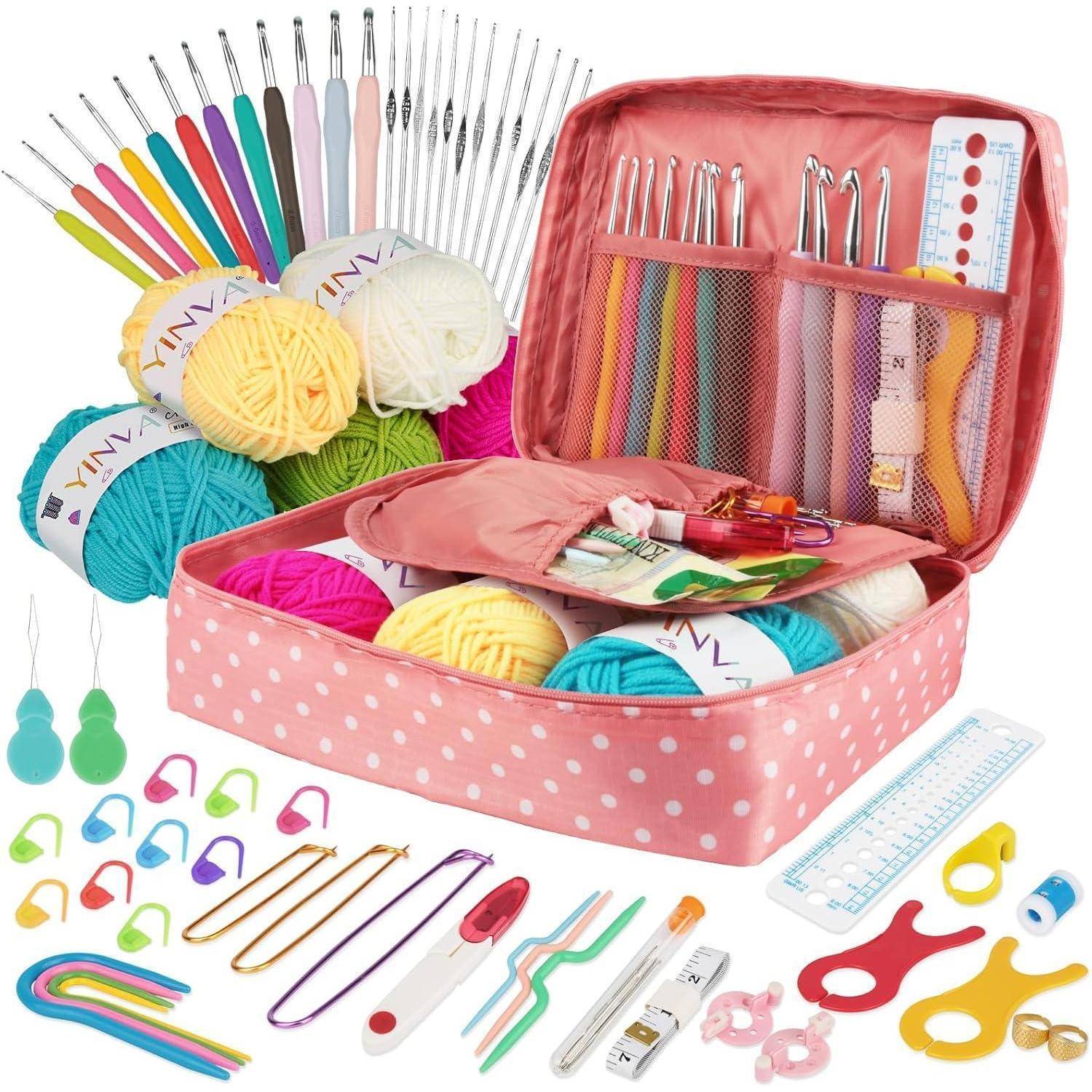 Eine rosa gepunktete Tasche, gefüllt mit Häkelutensilien wie Häkelnadeln, Wollknäueln in verschiedenen Farben, Maschenmarkierern, Schere, Lineal und Maßband.