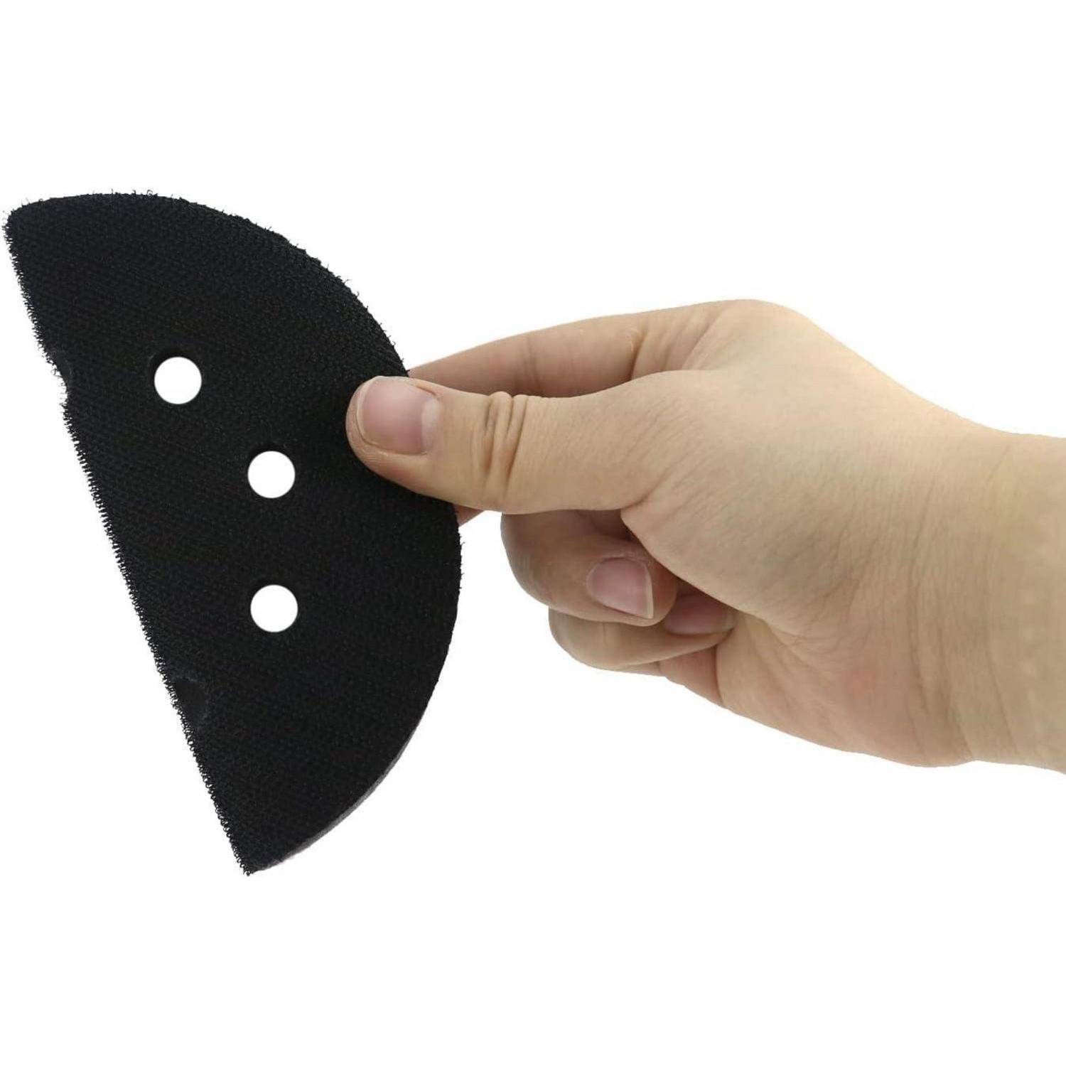 Eine Hand, die einen schwarzen, dreieckigen Schleifpad mit drei Löchern zur Befestigung hält.