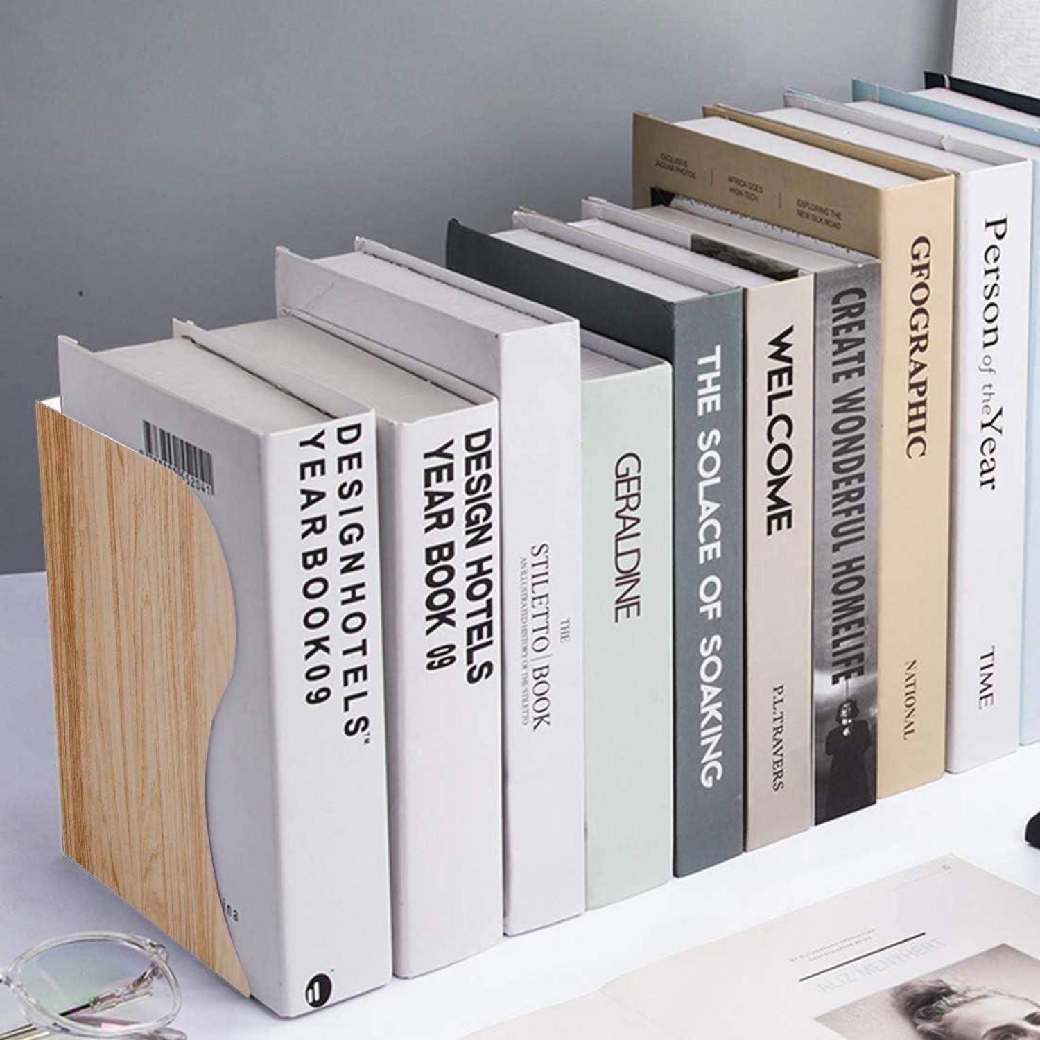 Eine Reihe von Hardcover-Büchern in einem Regal, darunter Titel wie ‚Design Hotels Jahrbuch 09', ‚Stiletto Buch' und ‚Die Tröstung des Eintauchens'.
