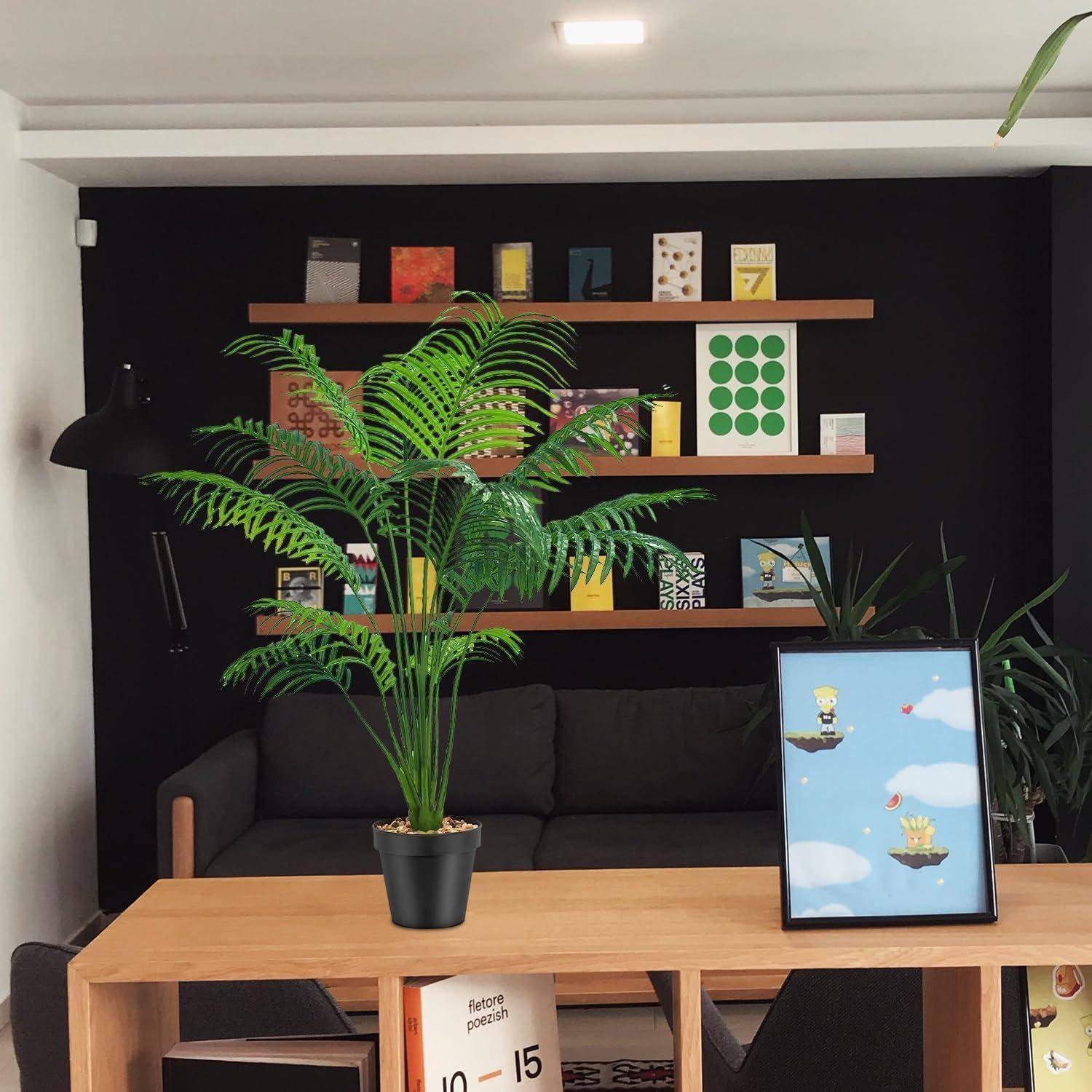 Ein Wohnzimmer mit einem grauen Sofa, einem Holztisch und einer Topfpflanze. Regale präsentieren farbenfrohe Bücher und Kunst an einer schwarzen Wand.